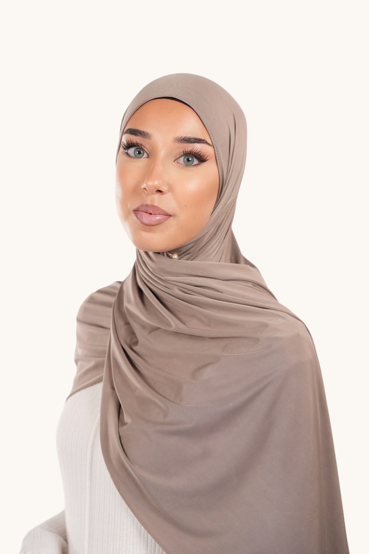 Dunkelbeiger Liquid Jersey Hijab von Losyana.Shop, weiches Stoffmaterial, zeigt den stilvollen, fließenden Hijab auf einem Model.