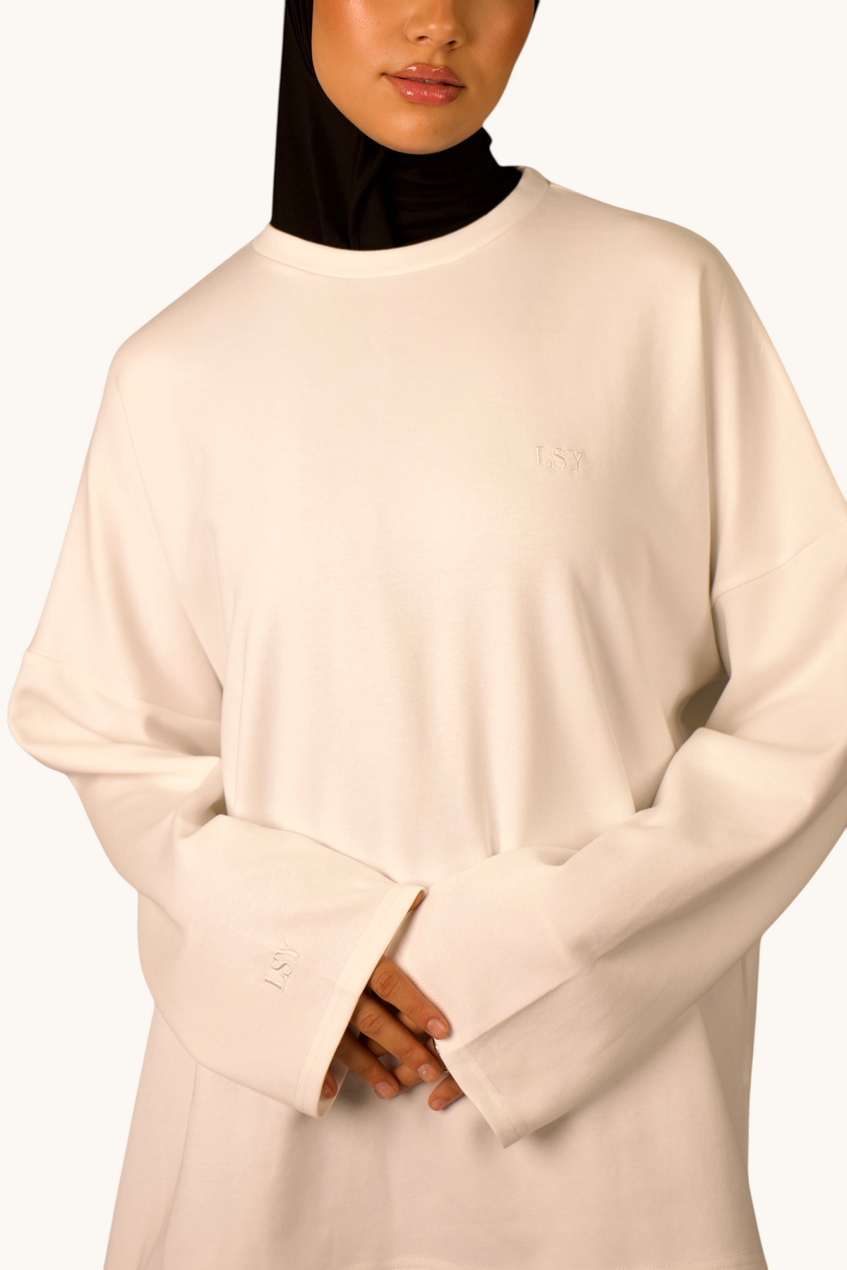 LOSYANA LSY Langarmshirt in Weiß aus weicher Baumwolle mit dezenter Logostickerei, getragen mit schwarzem Hijab