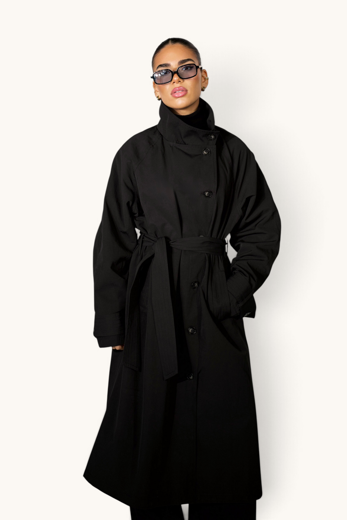 Schwarzer langer Trenchcoat von LOSYANA, eleganter Mantel aus wetterfestem Material, mit Gürtel und klassischen Revers.