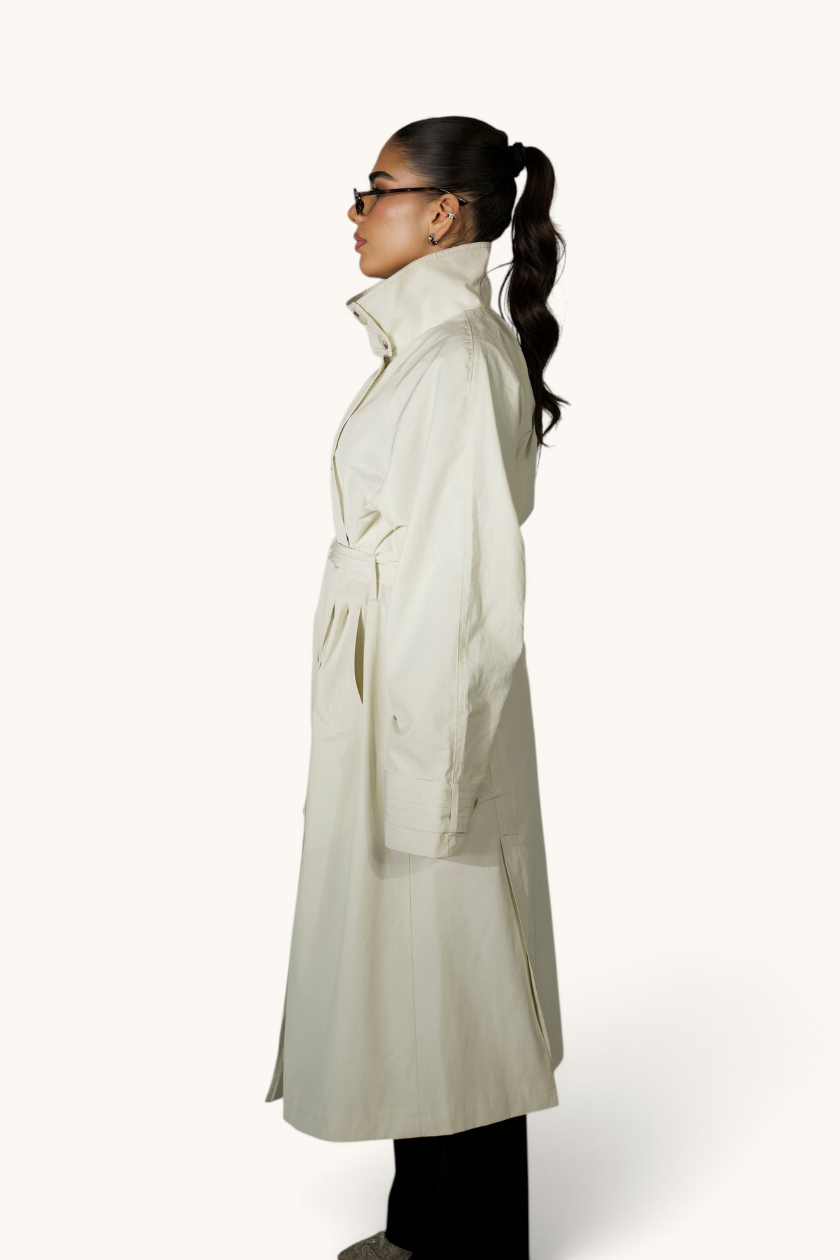 Langer cremiger Trenchcoat von LOSYANA, eleganter Mantel mit Gürtel und klassischen Reißverschlüssen, Blick auf Details und Stoffstruktur