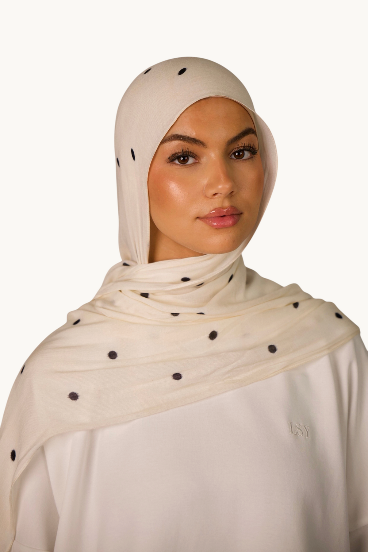 LOSYANA leichter Modal Hijab in Creme mit schwarzen Velour-Punkten, getragen von einem Model mit passender Bone.