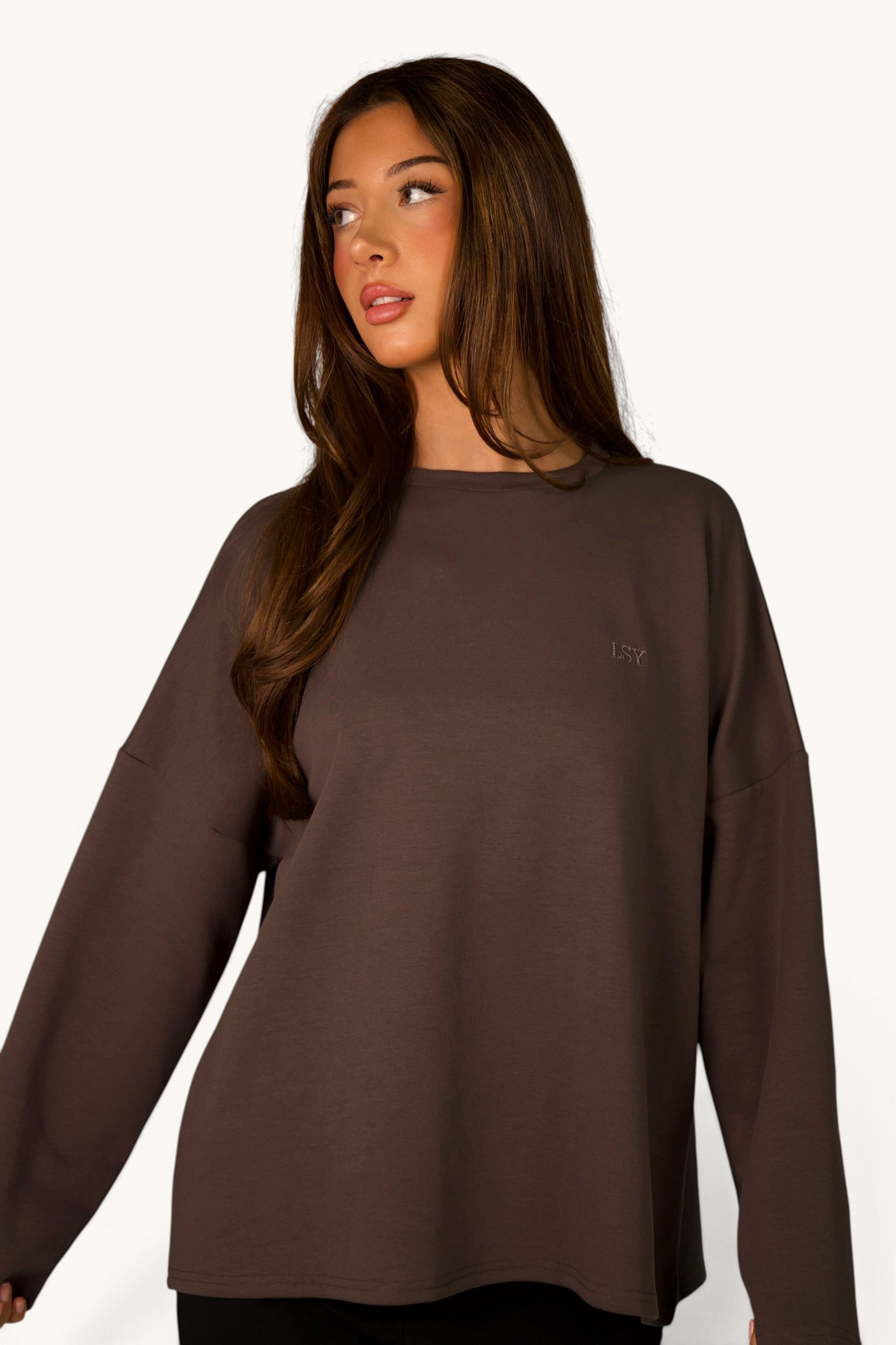 LOSYANA LSY Langarmshirt in Grau aus weicher Baumwolle mit dezentem Logo-Stick an einer Frau