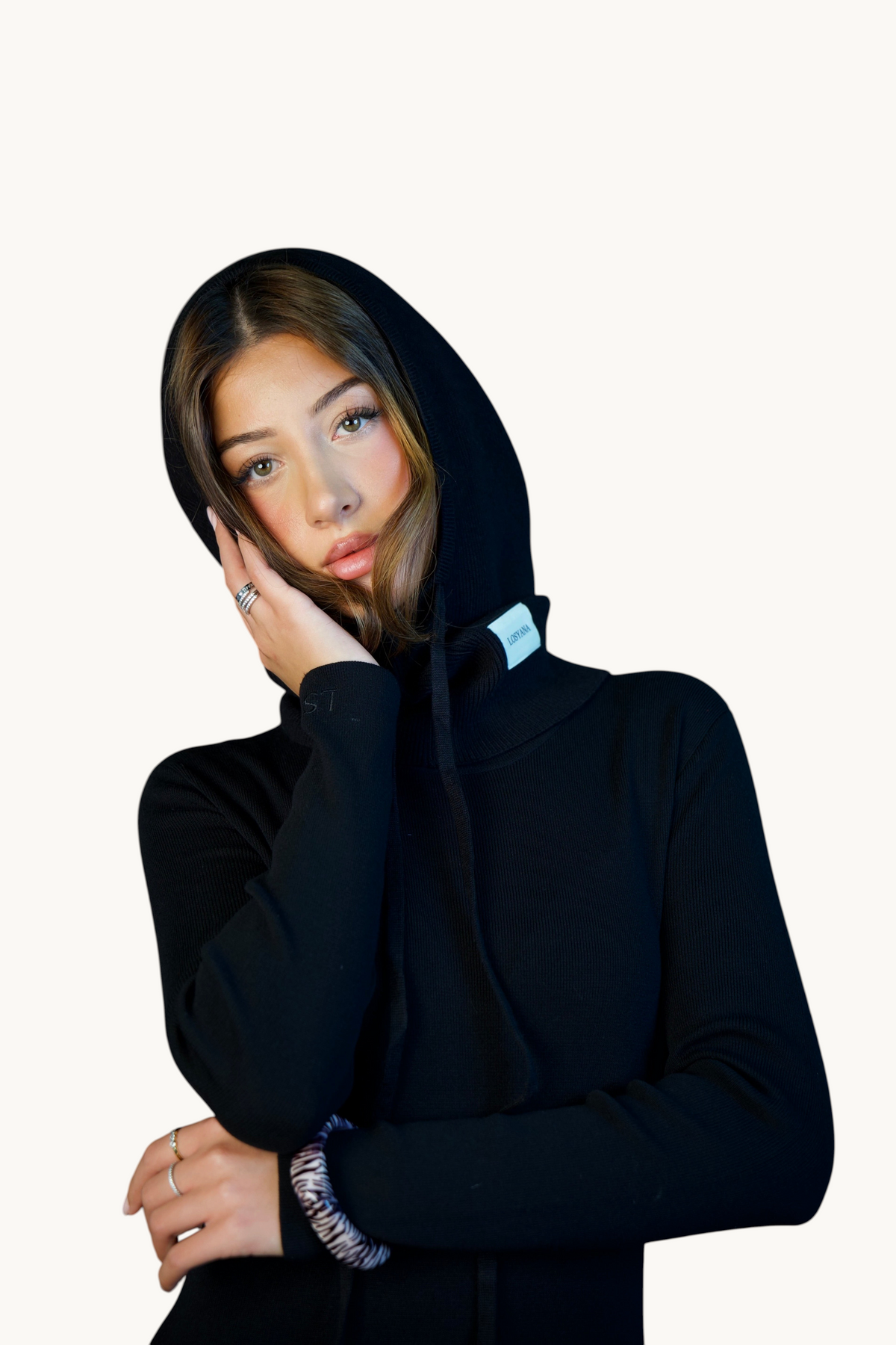 LOSYANA Balaclava in Schwarz mit Kapuze, weichem Material, Kordelzug und Logo-Patch, getragen von einer jungen Frau.