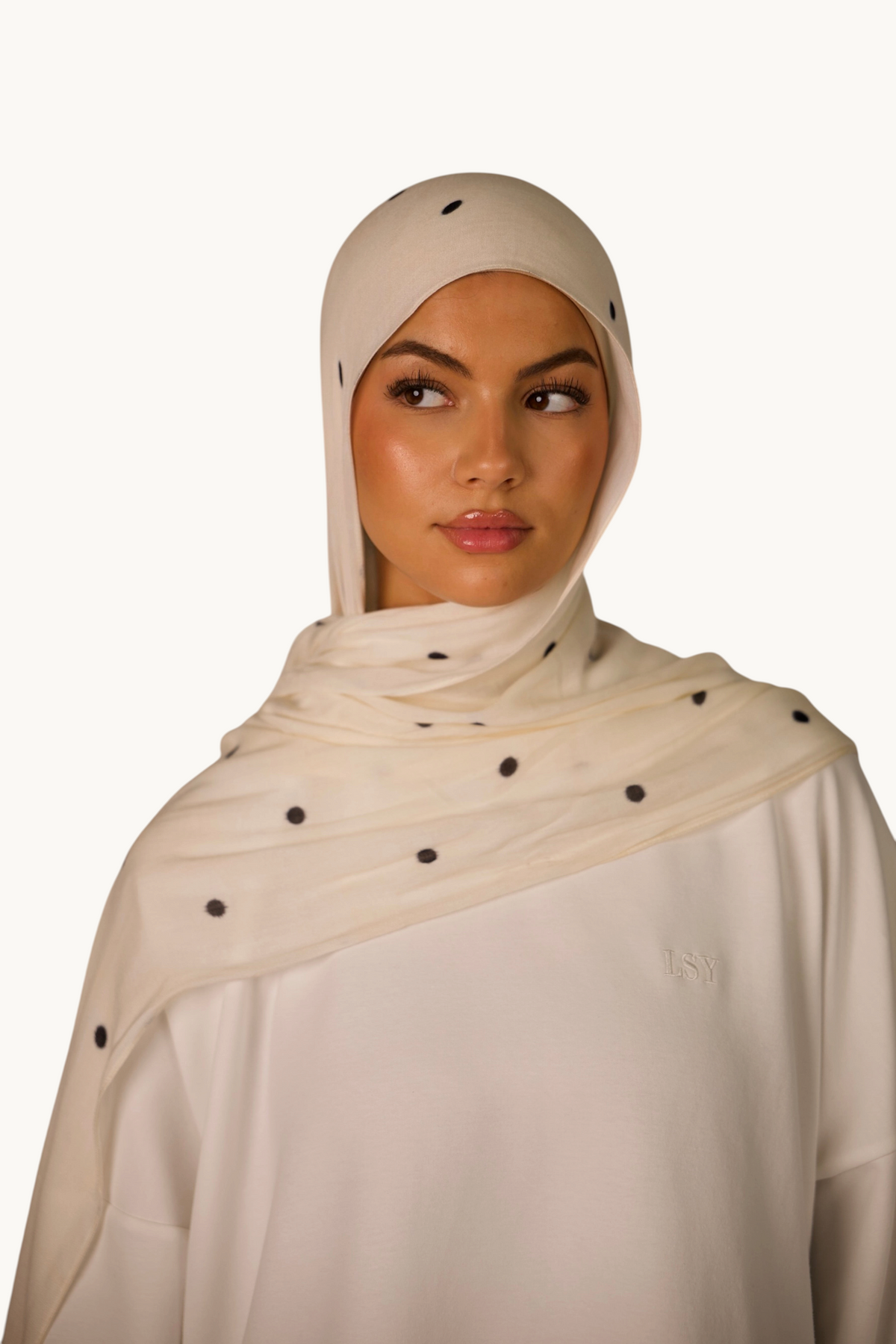 LOSYANA leichter Modal Hijab in Creme mit schwarzen Velour-Punkten, getragen von einem Model mit passender Bone.