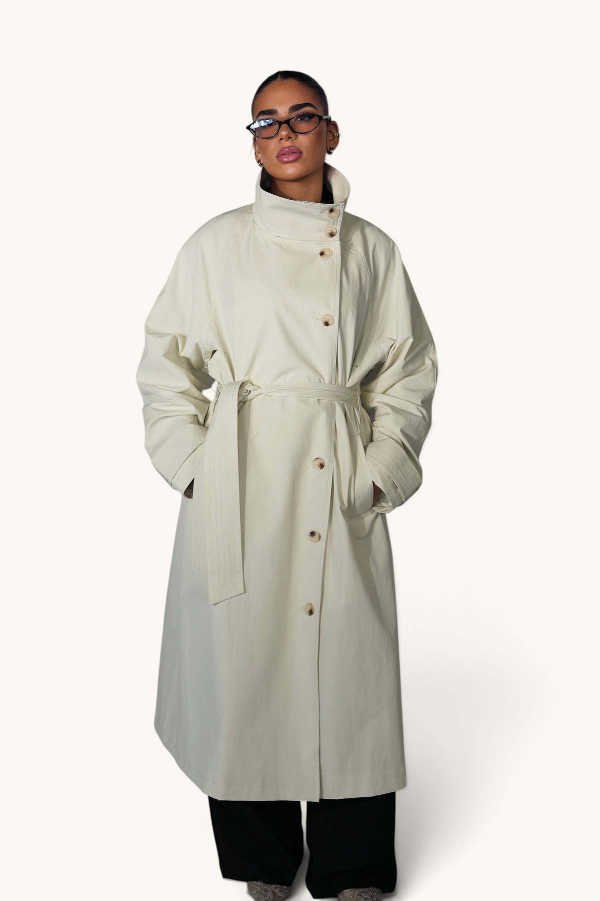 Langer cremiger Trenchcoat von LOSYANA aus robustem Mantelmaterial, mit Gürtel und klassischen Reißverschlussdetails.