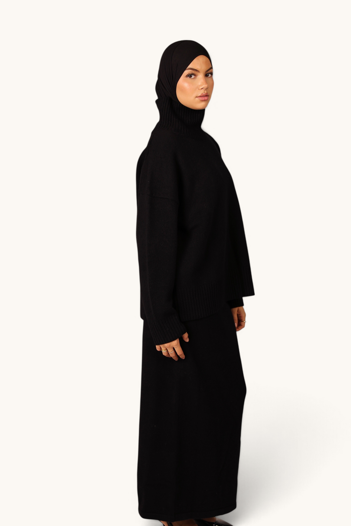 LOSYANA Wollpullover in Schwarz mit Stehkragen aus 100% Wolle, getragen von einem Model in Seitenansicht