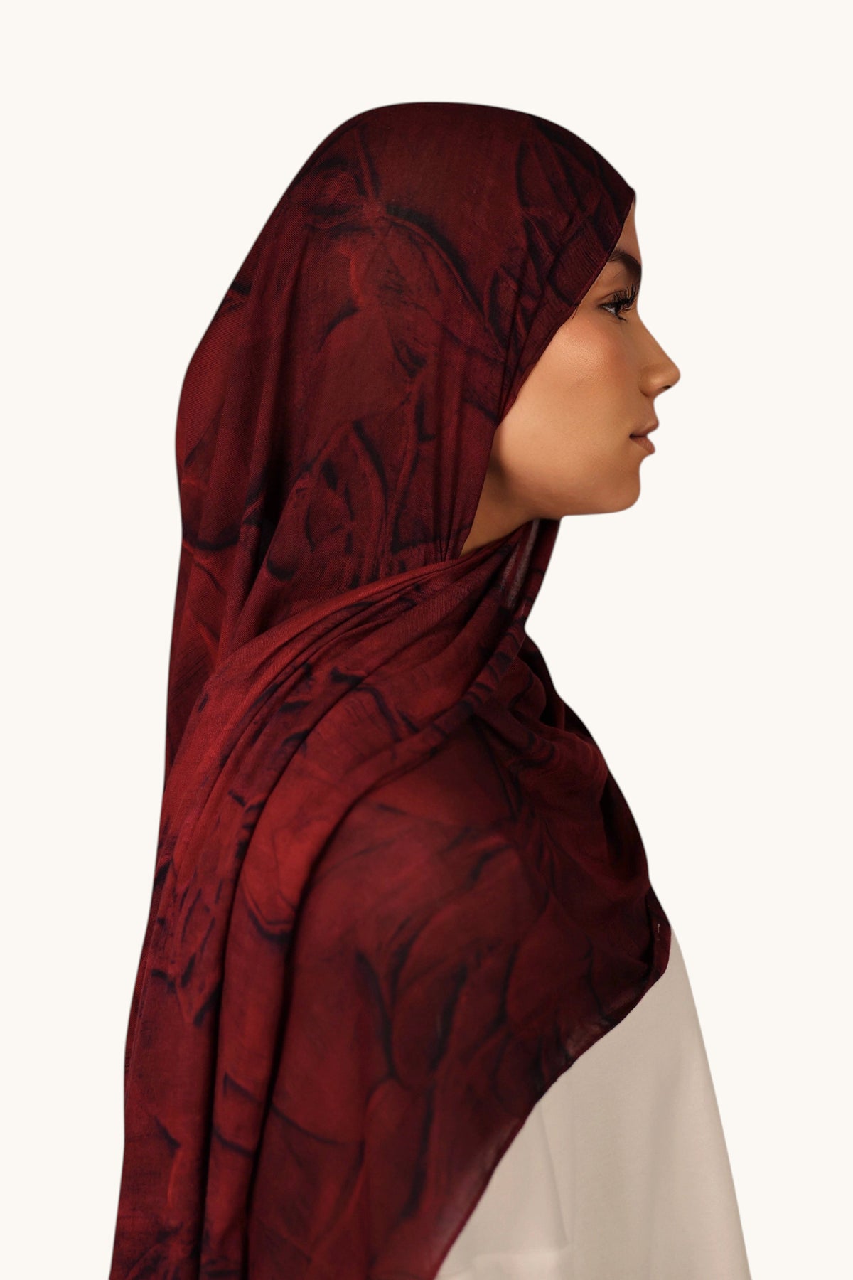 LOSYANA leichter Modal Hijab in Rouge mit dezenter Transparenz, getragen von einem Model im Profil.