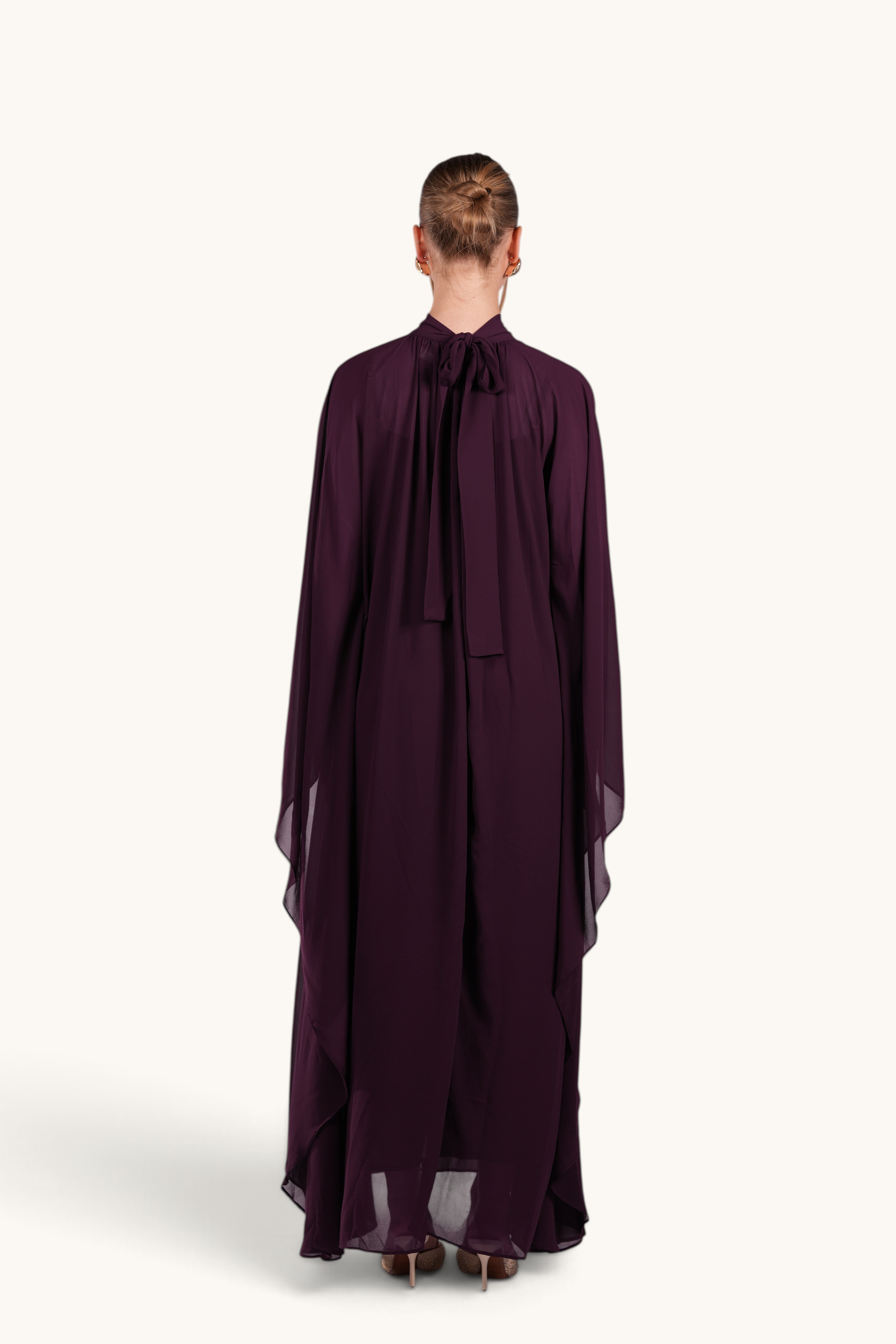 Back view of LOSYANA Andalusia mulberry chiffon cape dress with a tie-neck detail on a model