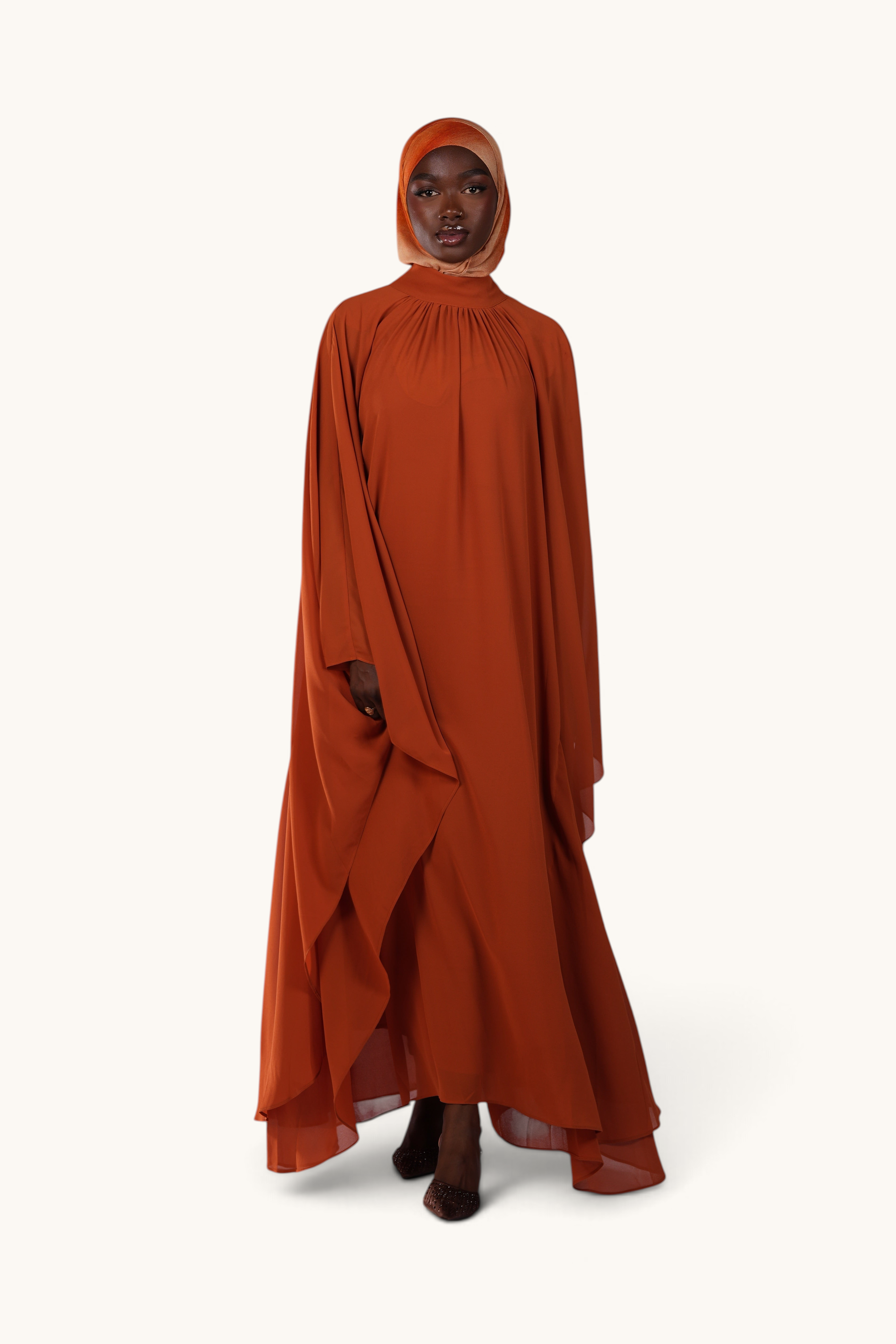 LOSYANA Andalusia sunset orange chiffon cape dress with matching hijab worn by a model on a white background