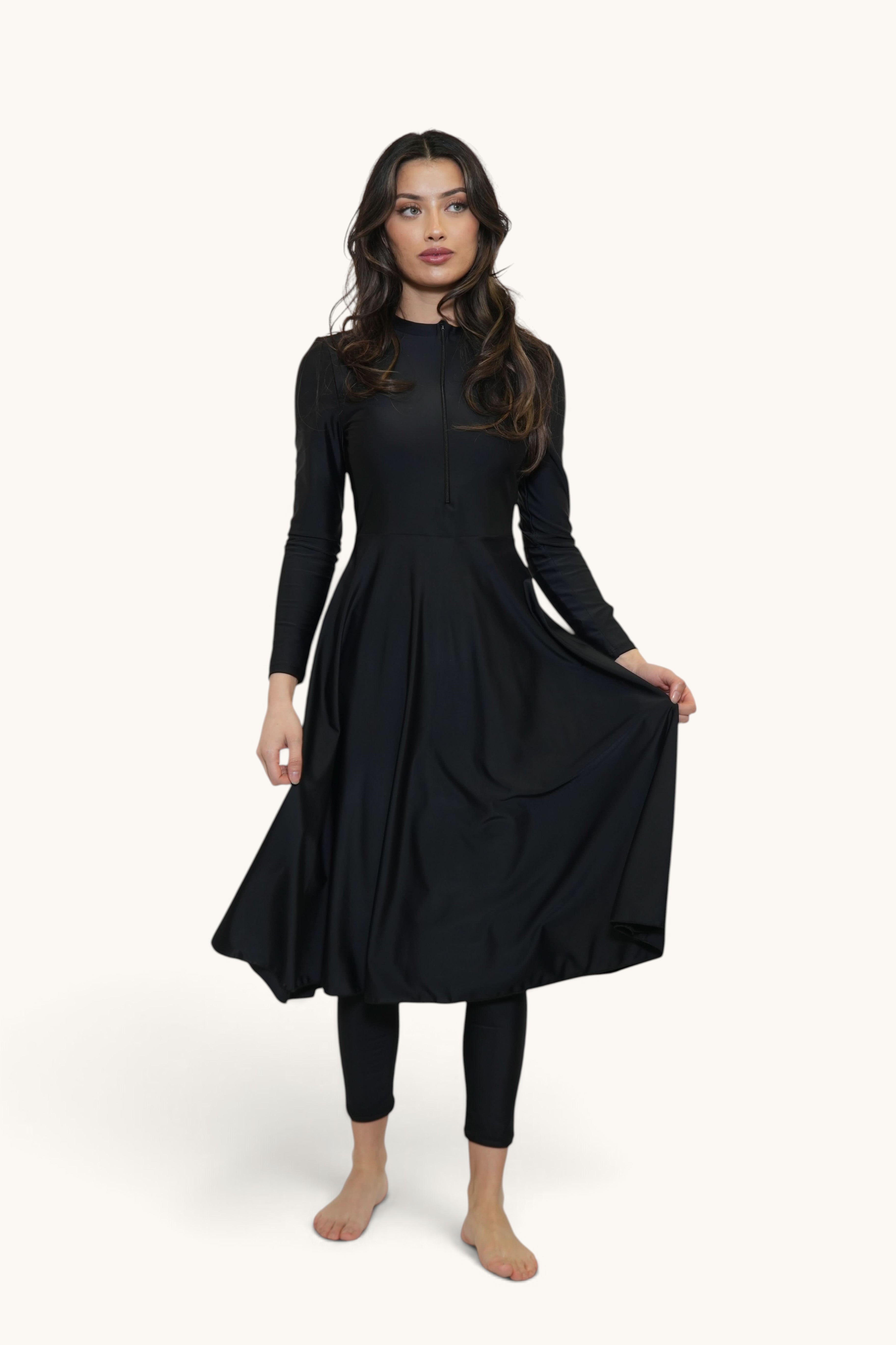 Model wearing a black LOSYANA Azzurra long-sleeve burkini set with a flared tunic and leggings