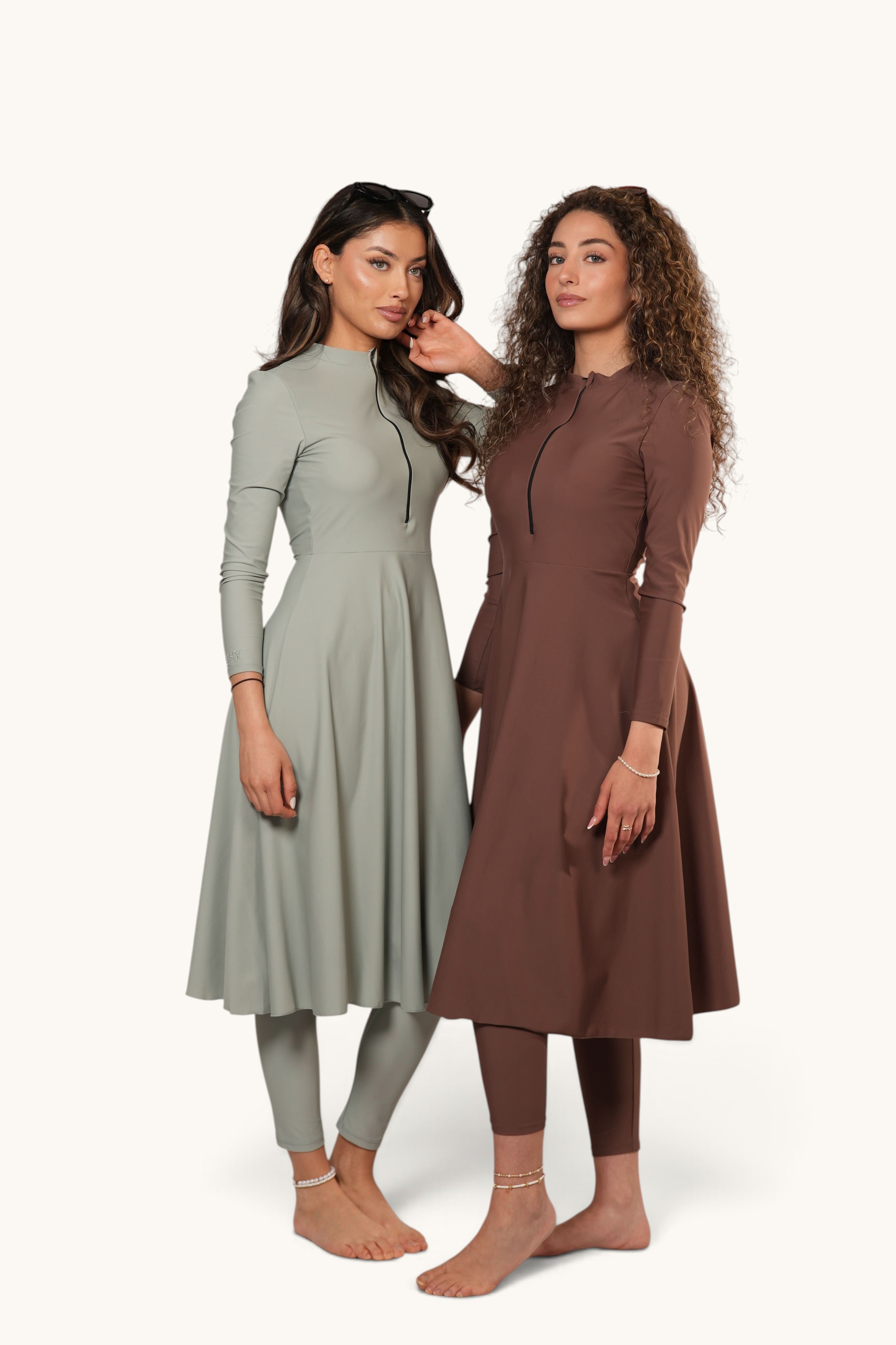 Two models wearing LOSYANA Azzurra burkini sets in mint and brown with long-sleeved tunics and matching leggings.