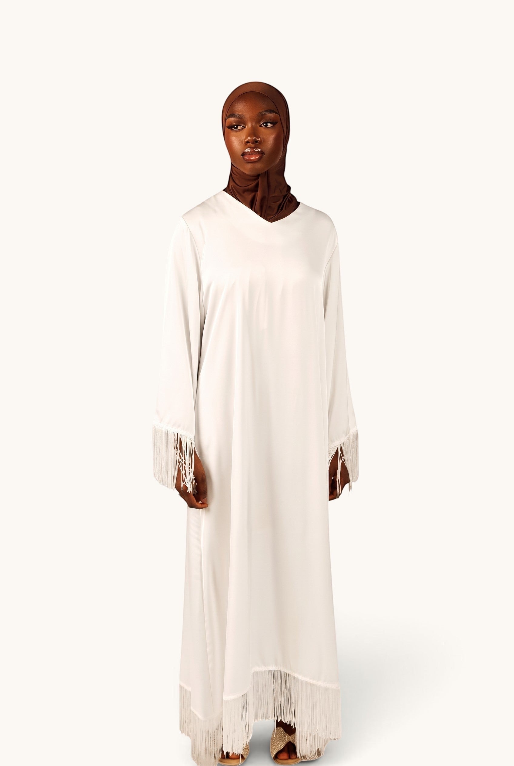 LOSYANA white satin Barcelona dress with fringe trim on sleeves and hem, worn by a model in a brown hijab