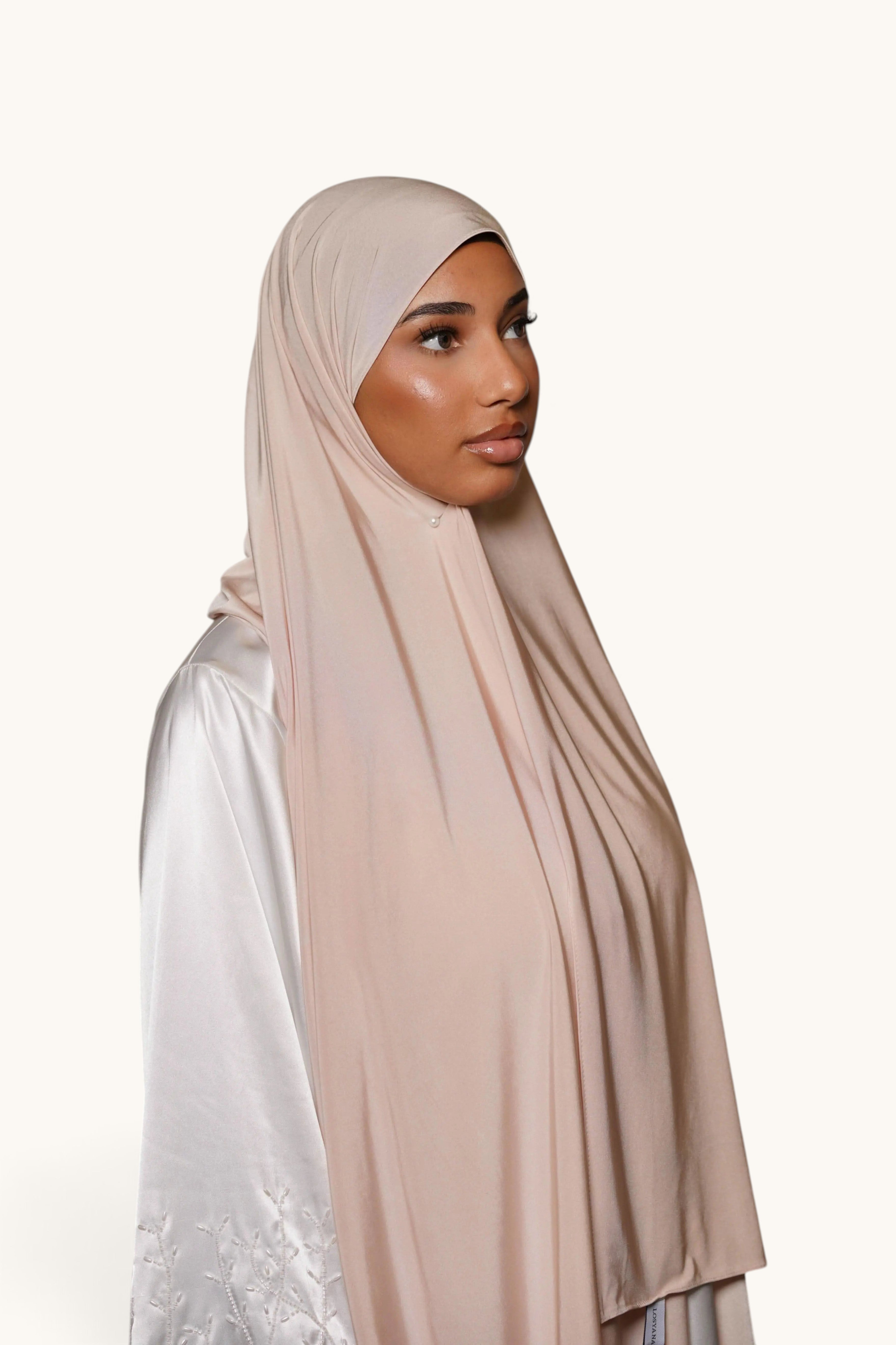 Model wearing a beige LOSYANA satin premium jersey hijab, featuring a smooth, non-slip drape against a white background