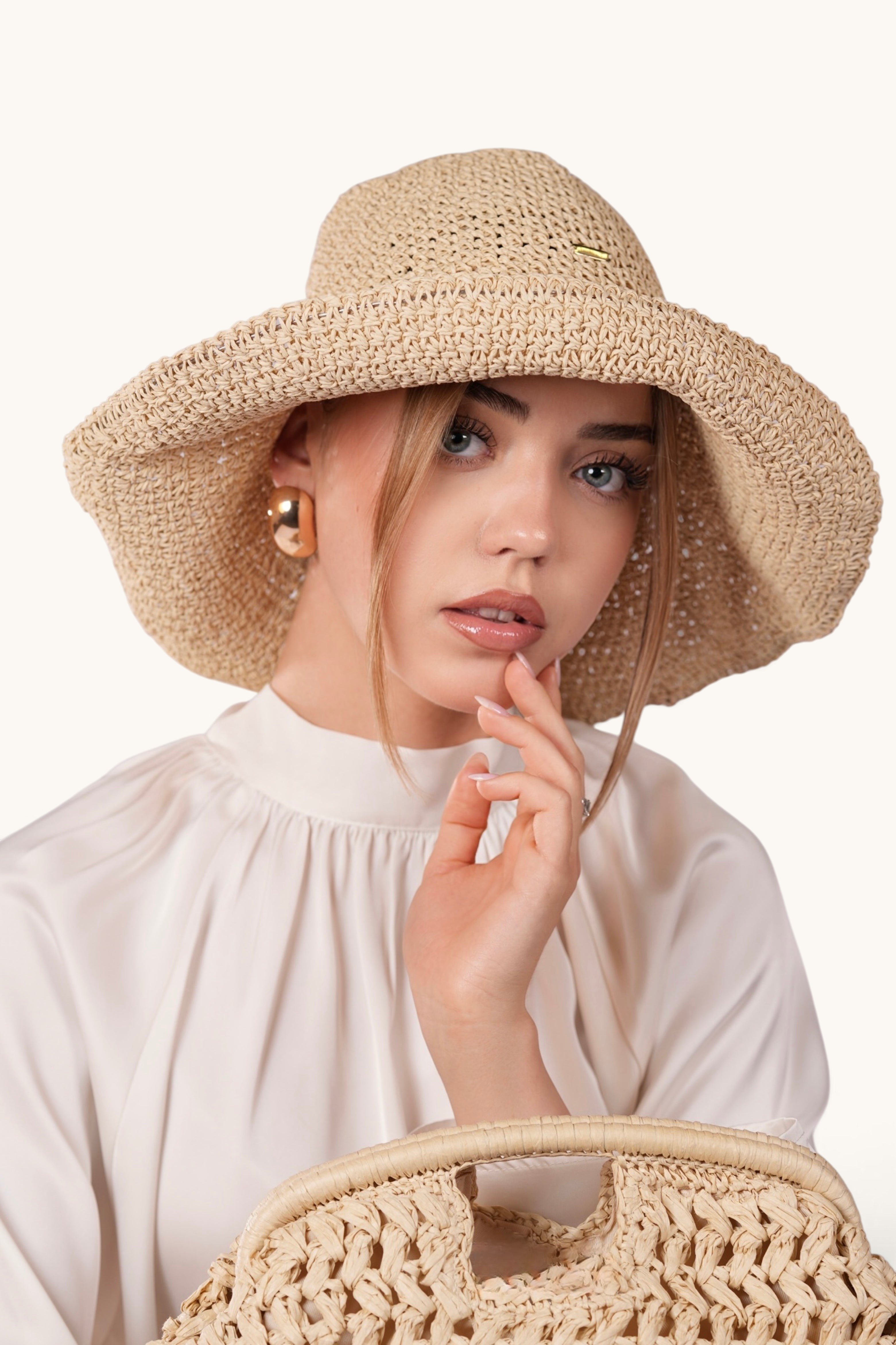 LOSYANA beige straw hat with adjustable brim worn by a woman in a white blouse, studio portrait.