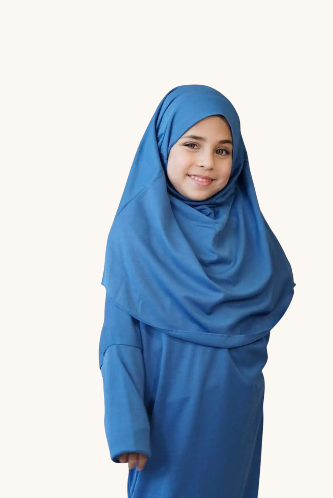 Young girl wearing a soft blue LOSYANA jersey prayer dress with an attached matching hijab for comfortable prayer.