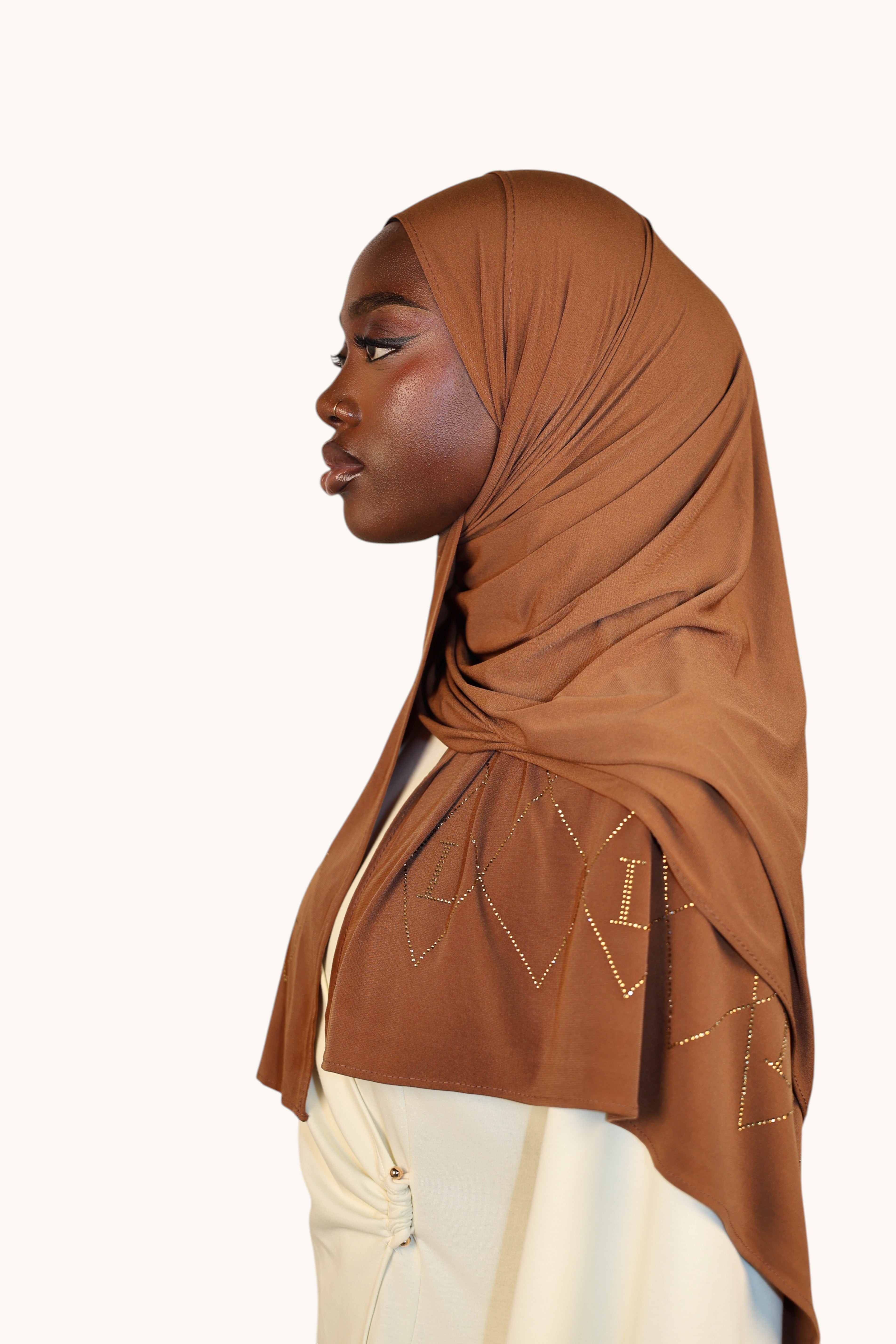 LOSYANA bronze premium jersey hijab with sparkling rhinestone L-pattern detail worn by a model in profile view