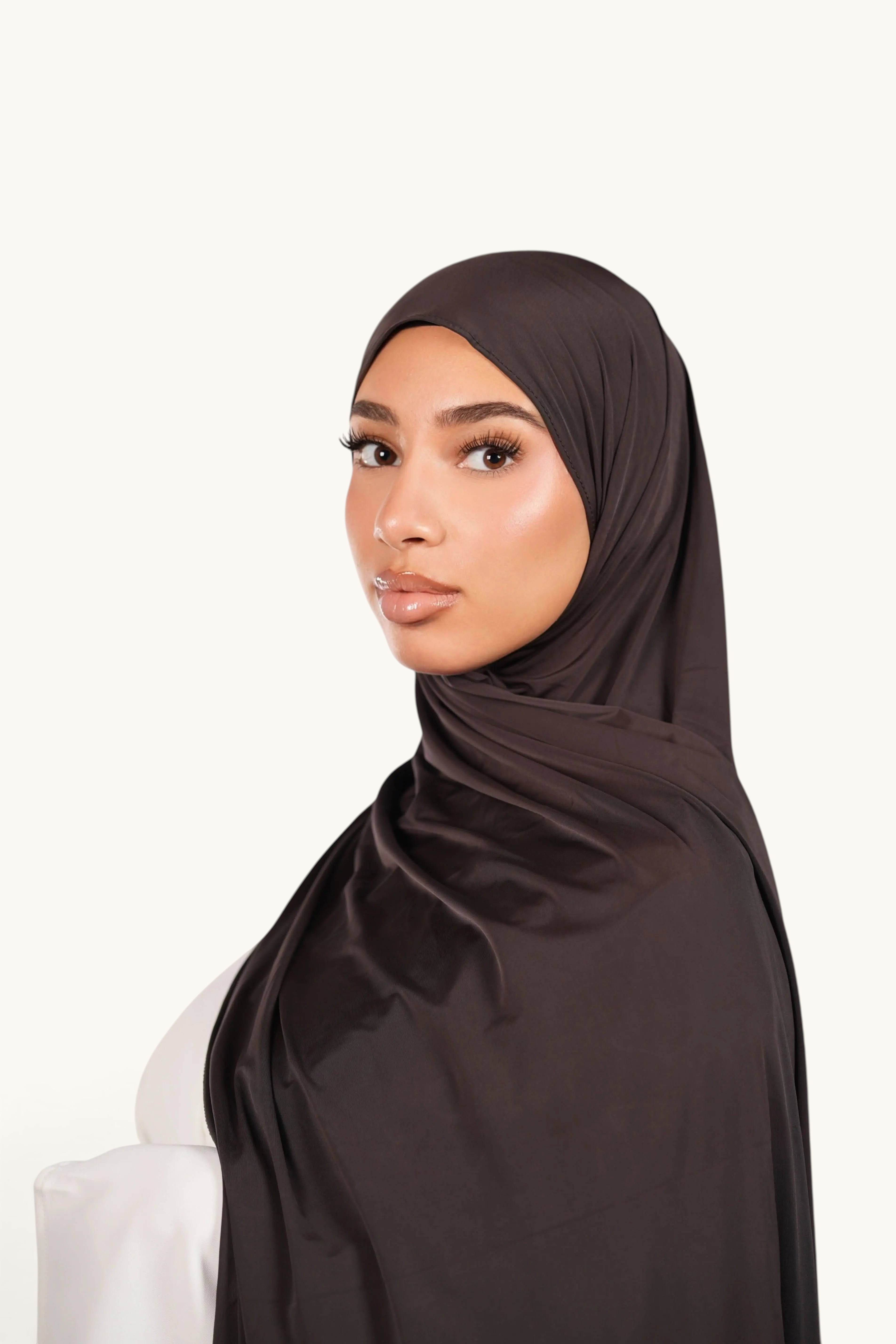 LOSYANA deep brown liquid jersey hijab worn by a model, featuring a lightweight, elegant, and slightly glossy finish.