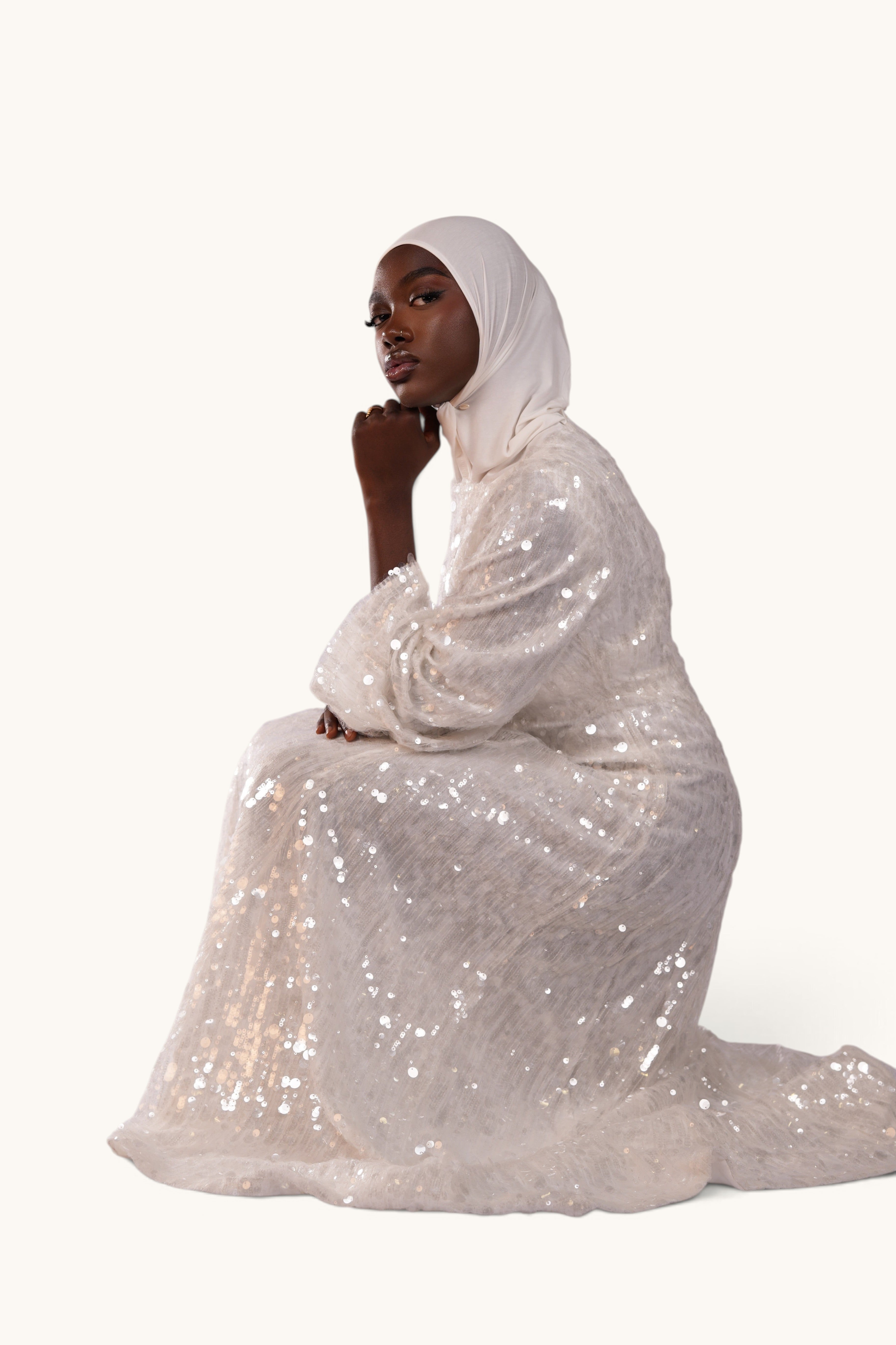 LOSYANA Formentera white sequin evening dress with trumpet sleeves worn by a model in a white hijab