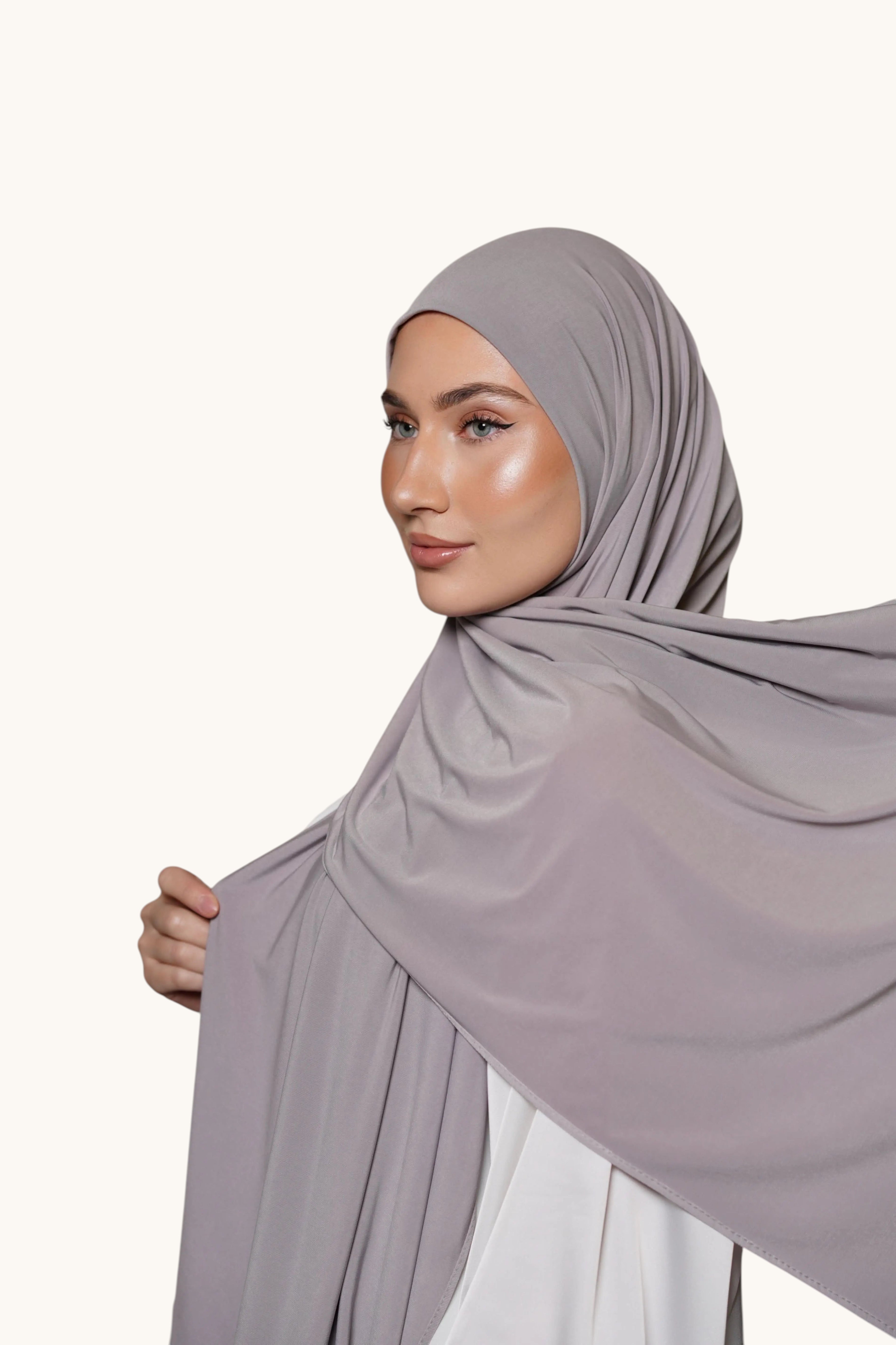 Model wearing a soft grey LOSYANA premium jersey hijab, featuring a non-slip, opaque, and comfortable fabric drape.