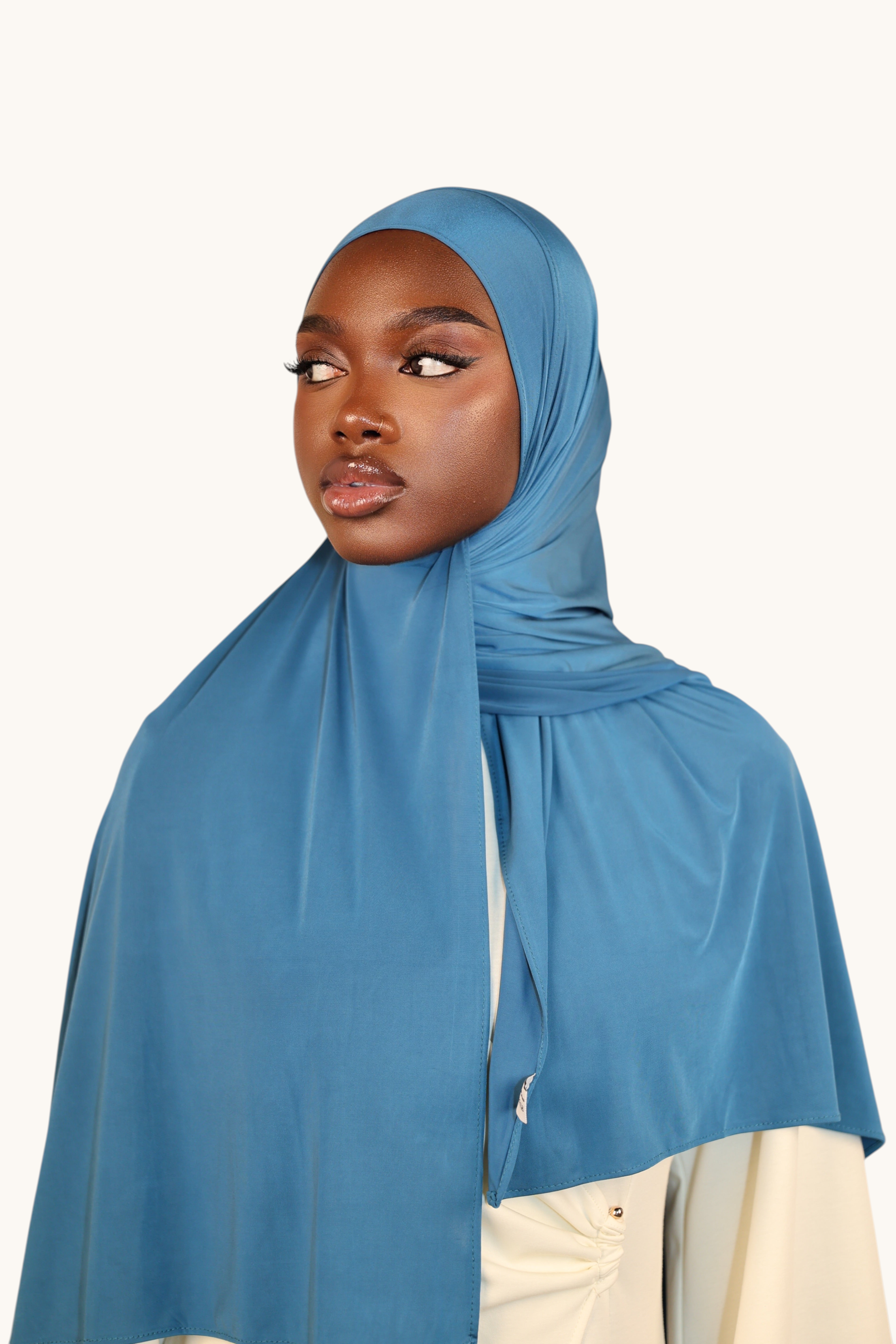 Model wearing a LOSYANA ice blue liquid jersey hijab with a subtle sheen, styled elegantly against a neutral background