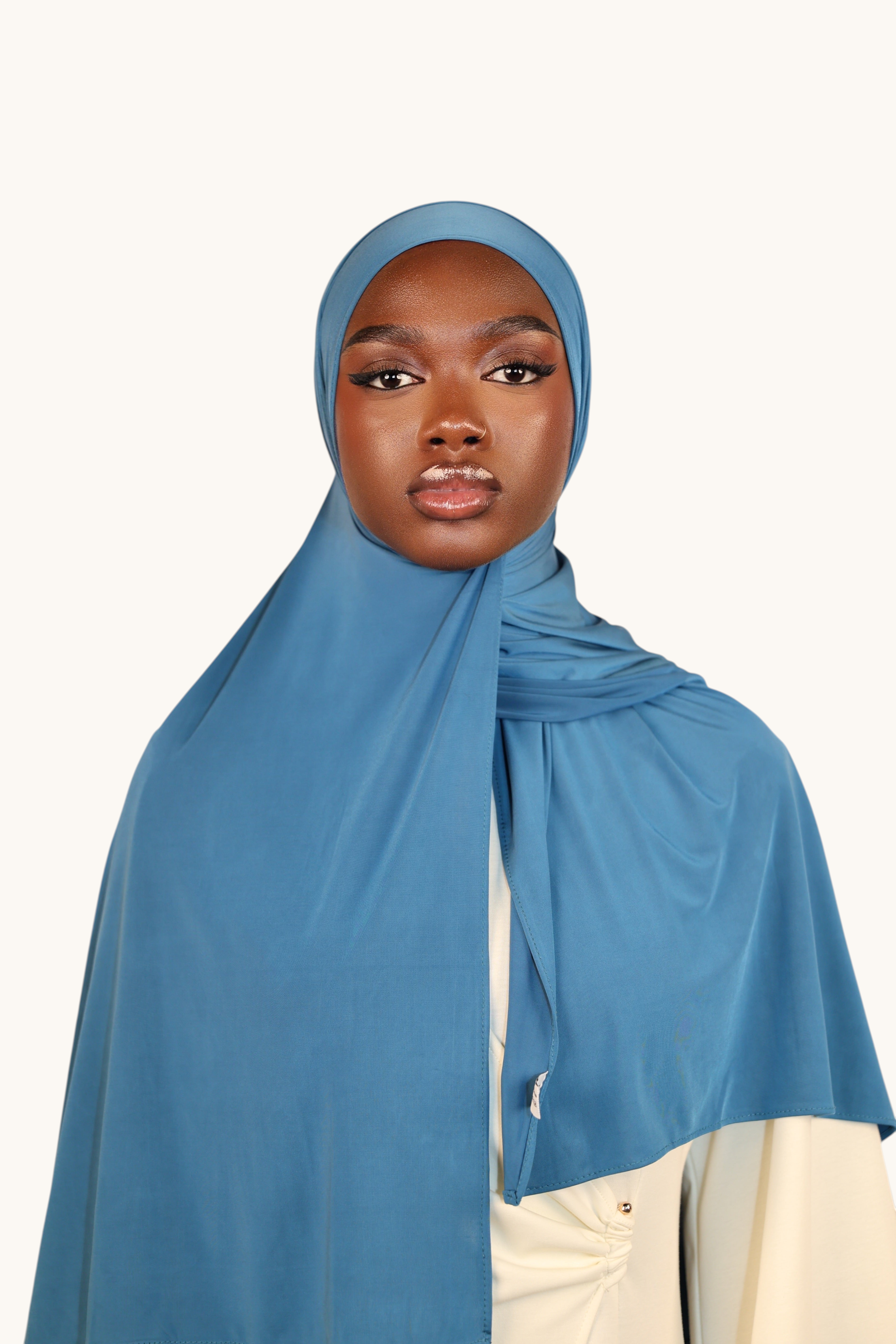 Model wearing a LOSYANA ice blue liquid jersey hijab with a subtle sheen and breathable, lightweight fabric.