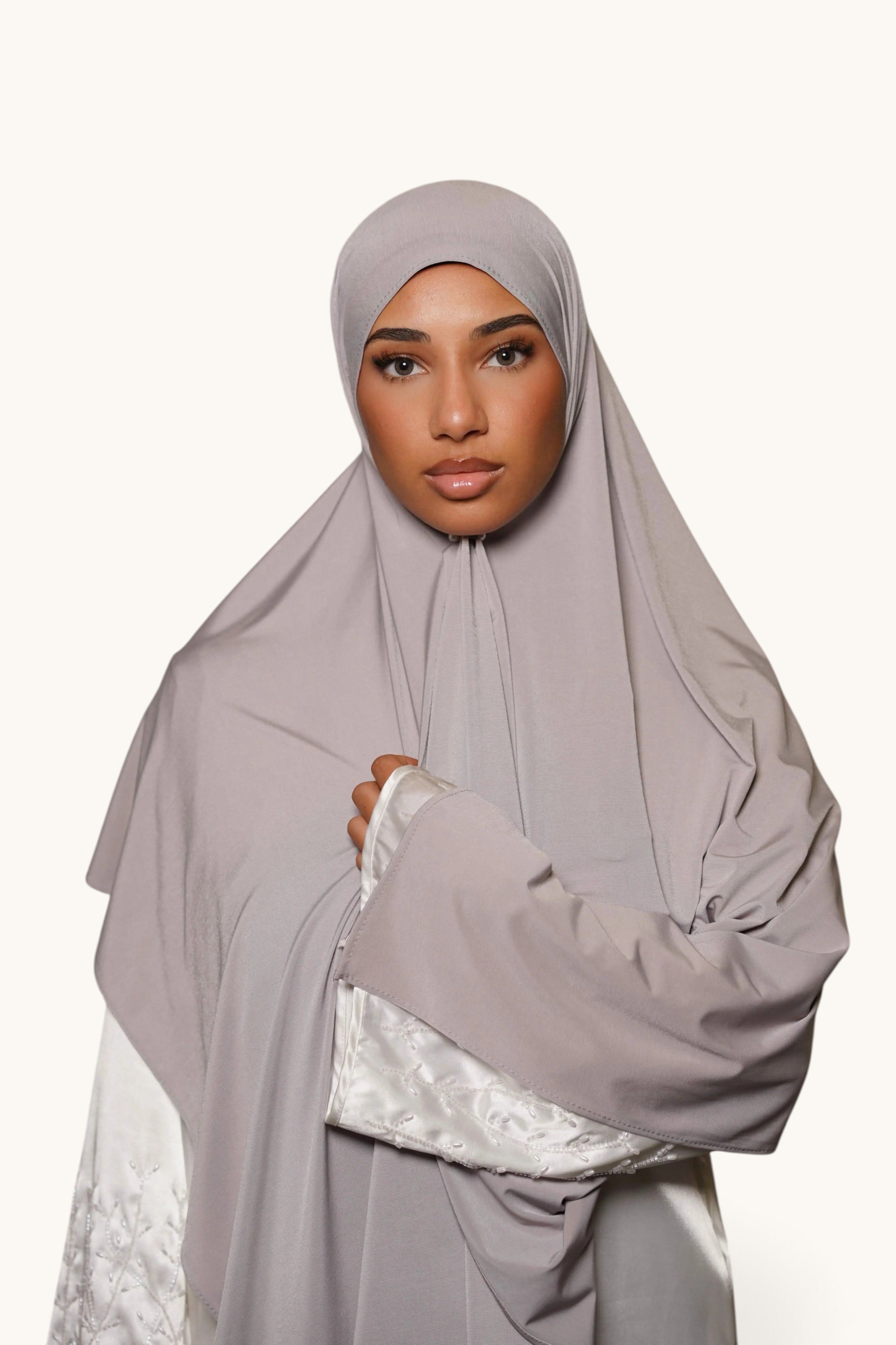 LOSYANA light grey satin jersey hijab worn by a woman, featuring a smooth, opaque, and non-slip fabric drape.
