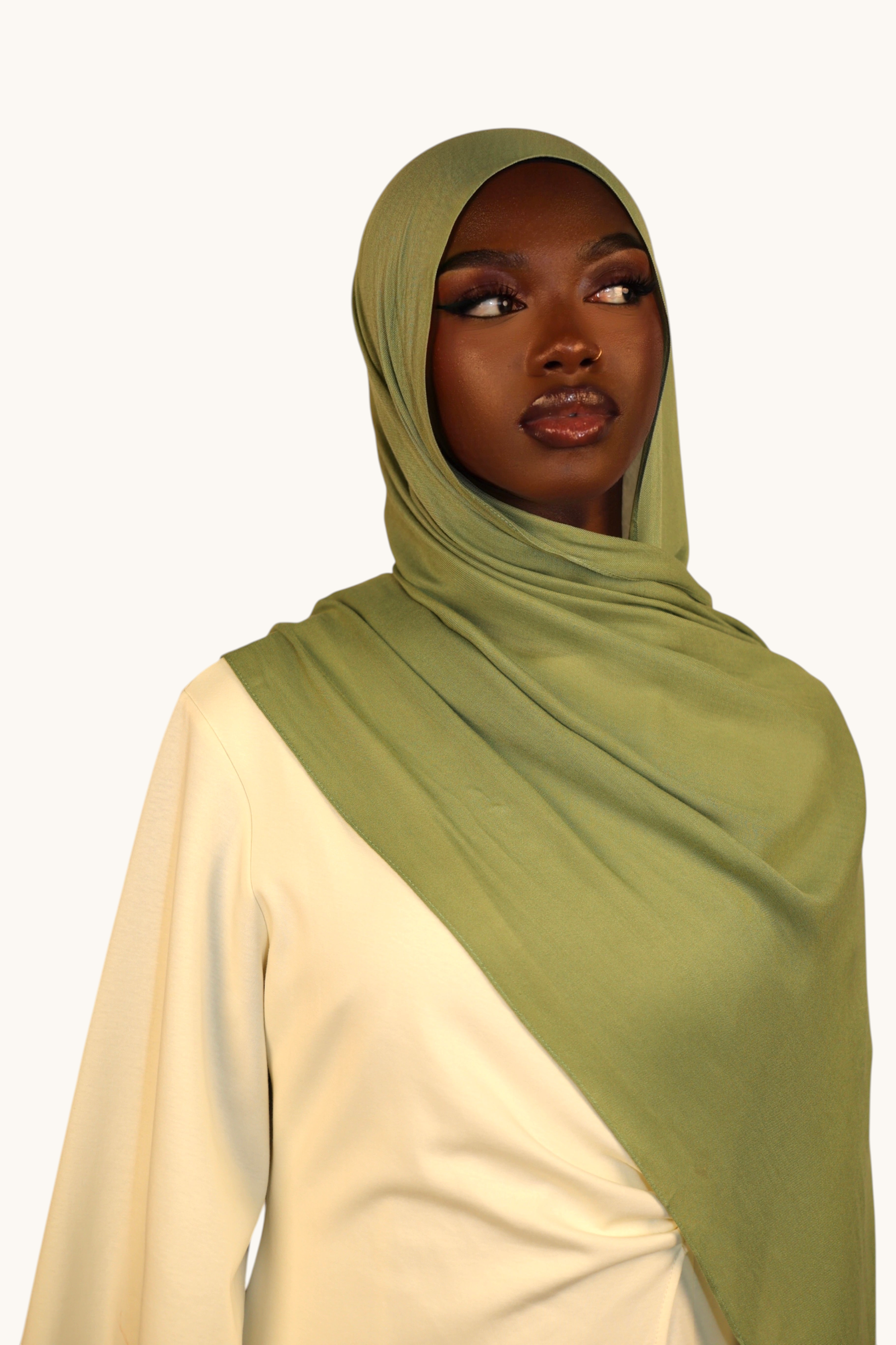 Model wearing a light olive green LOSYANA lightweight modal hijab with a soft, elegant drape.