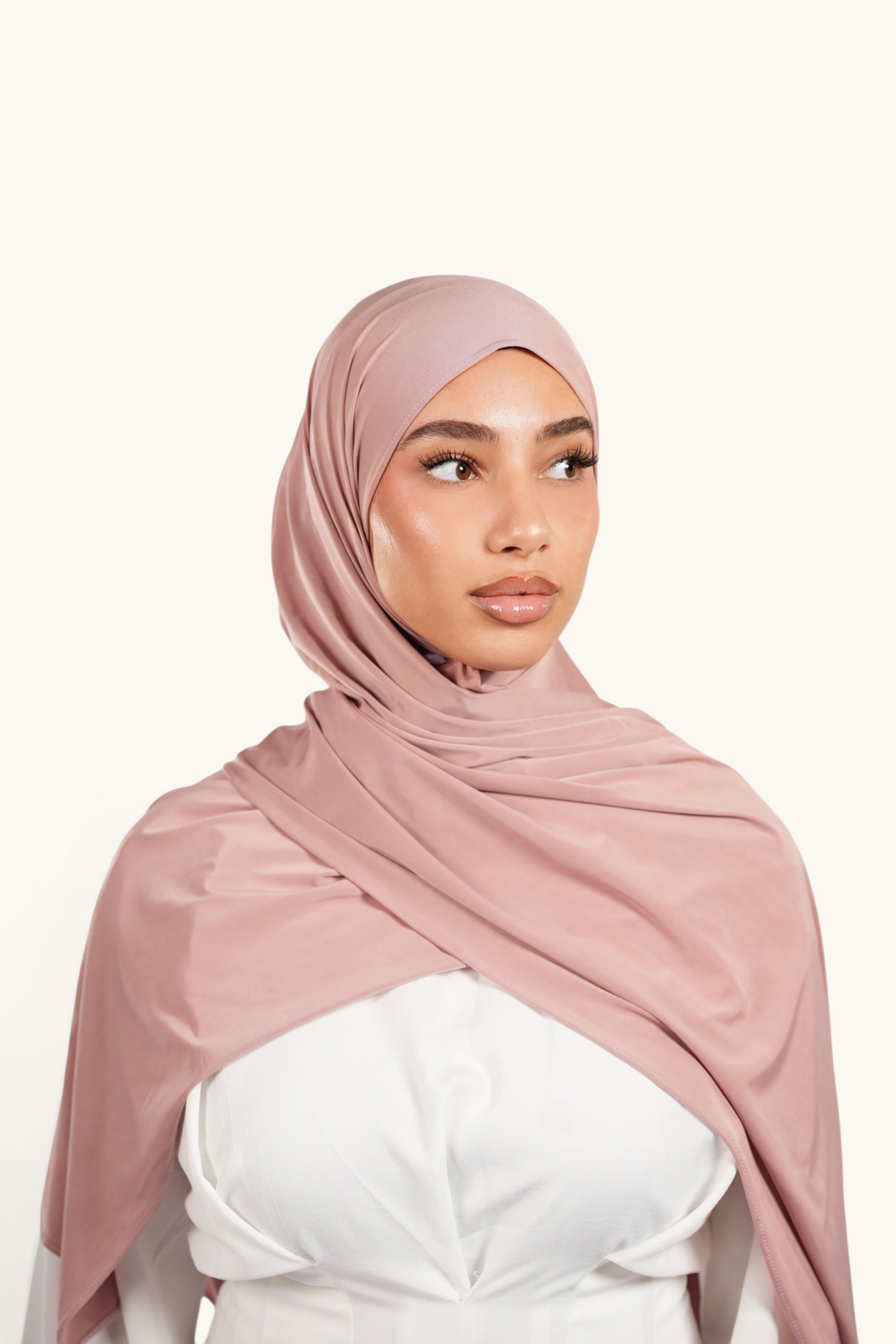 LOSYANA Liquid Jersey hijab in almond, a lightweight, breathable, and slightly glossy fabric worn by a model.