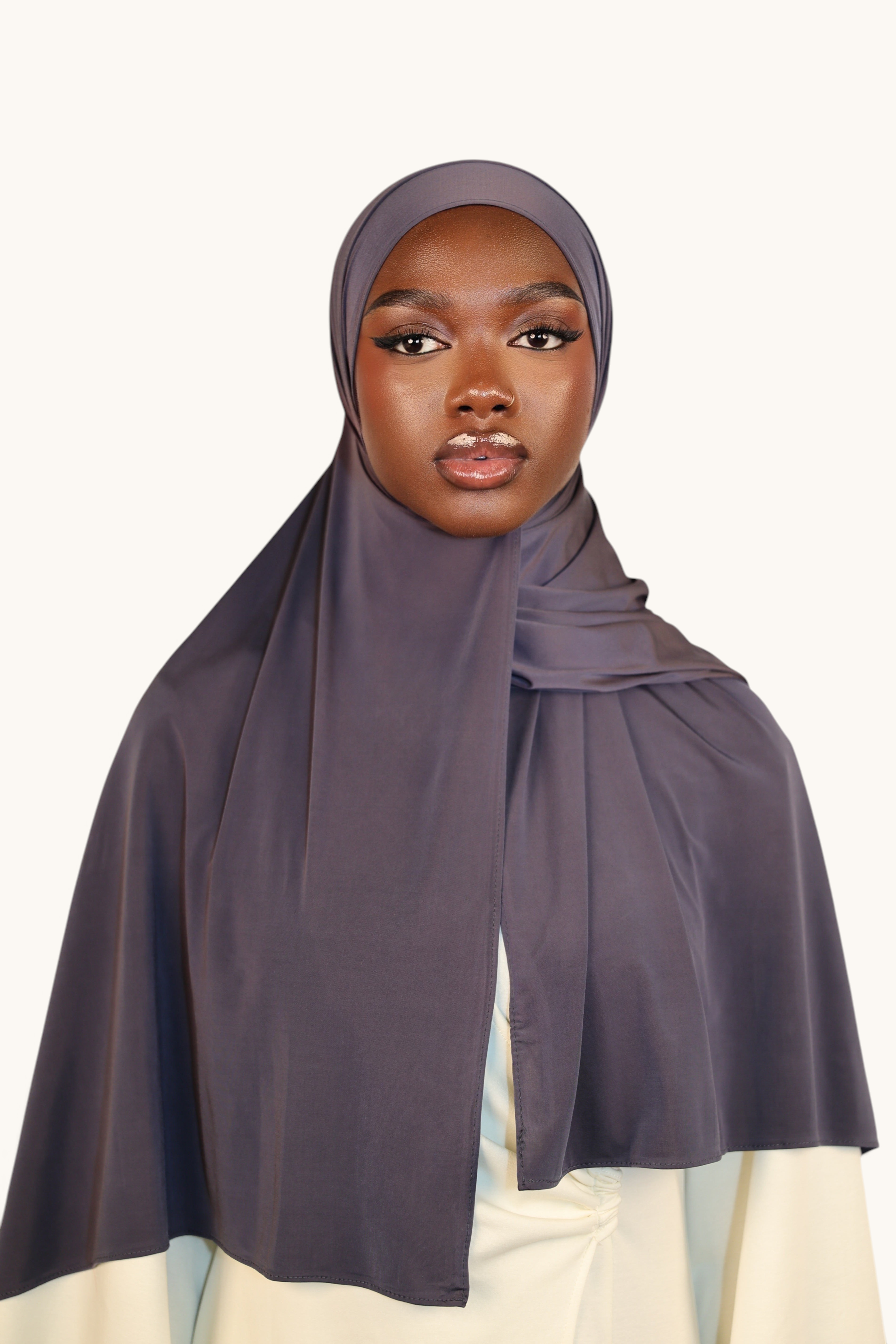 Model wearing a dusty blue LOSYANA Liquid Jersey hijab with a subtle sheen and breathable, lightweight fabric.