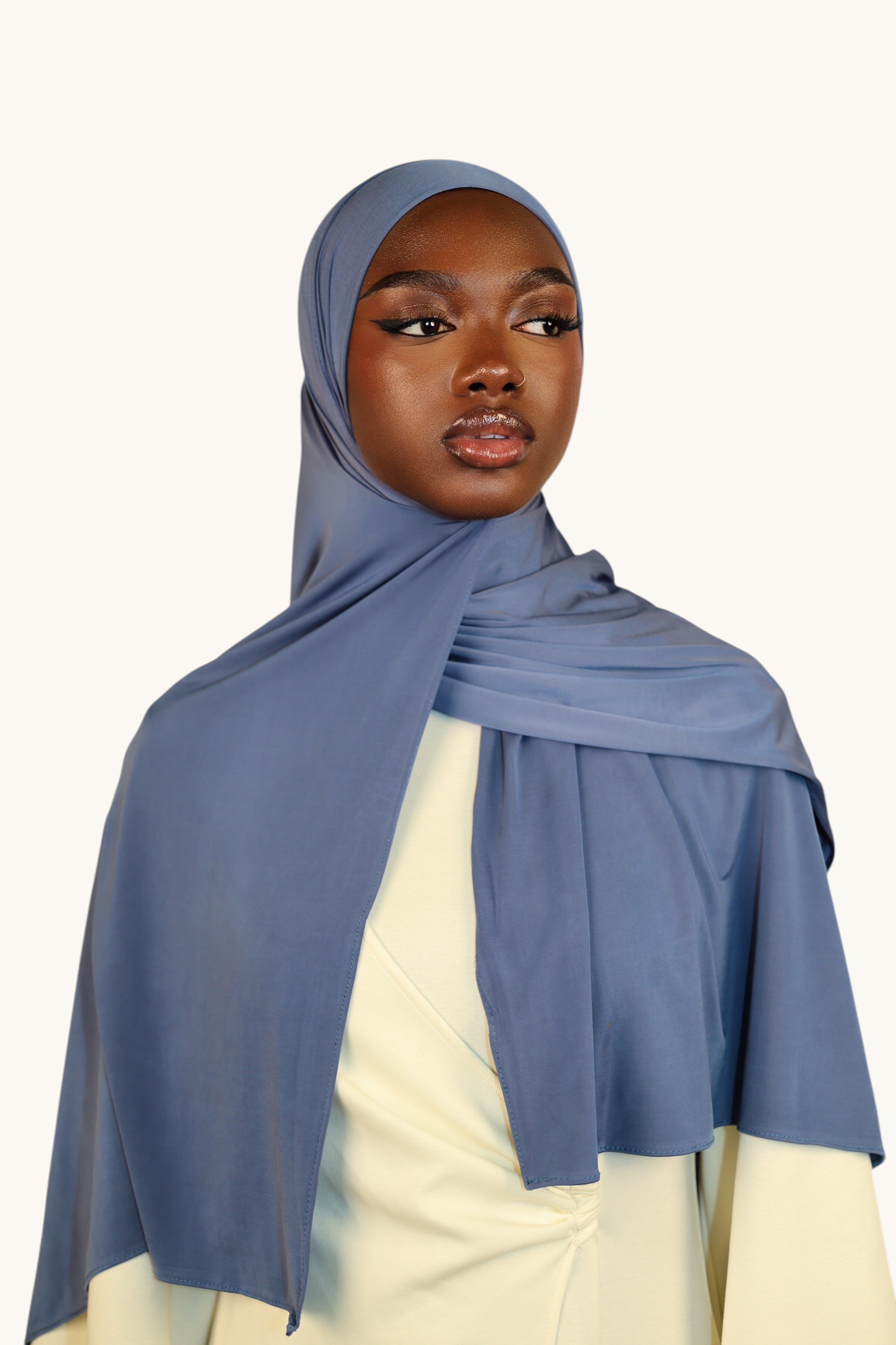 LOSYANA Liquid Jersey hijab in ocean blue, worn by a model with a light sheen finish and elegant drape.