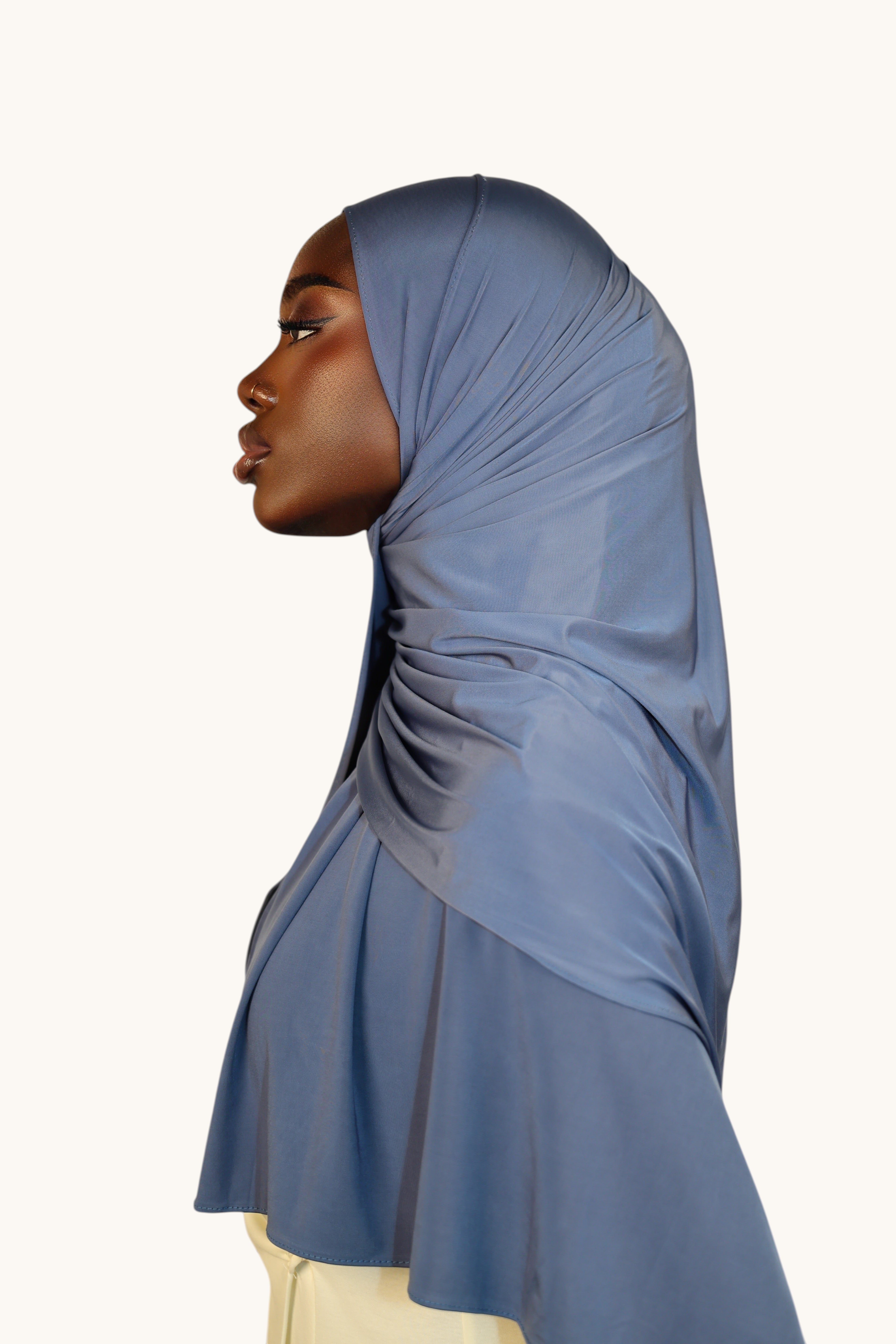 LOSYANA Liquid Jersey hijab in ocean blue worn by a model in profile view, showcasing the soft, satin-like sheen.