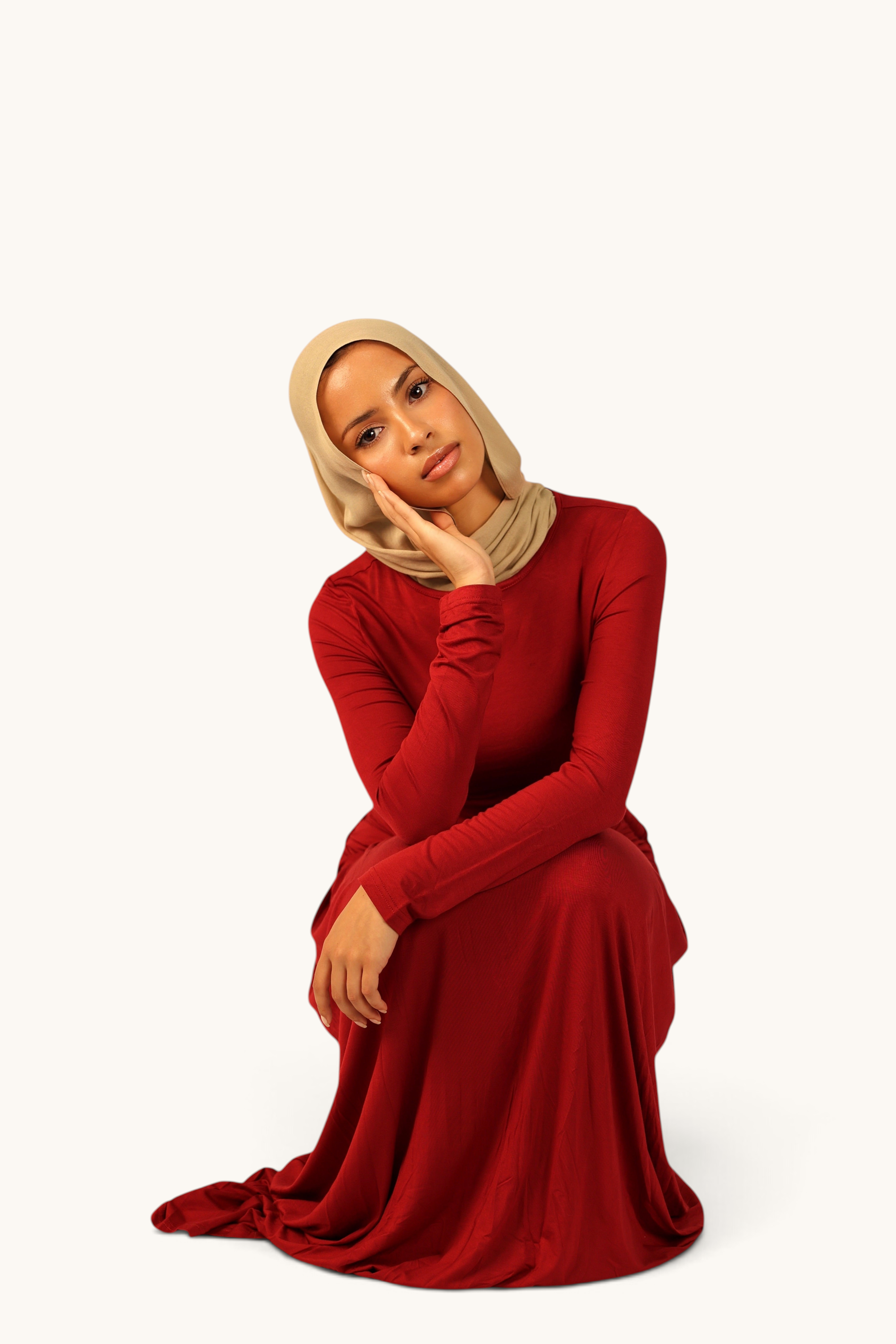 LOSYANA Marbella Jersey-Kleid in Rot mit Knotendetail, getragen von einem Model mit beigem Hijab.