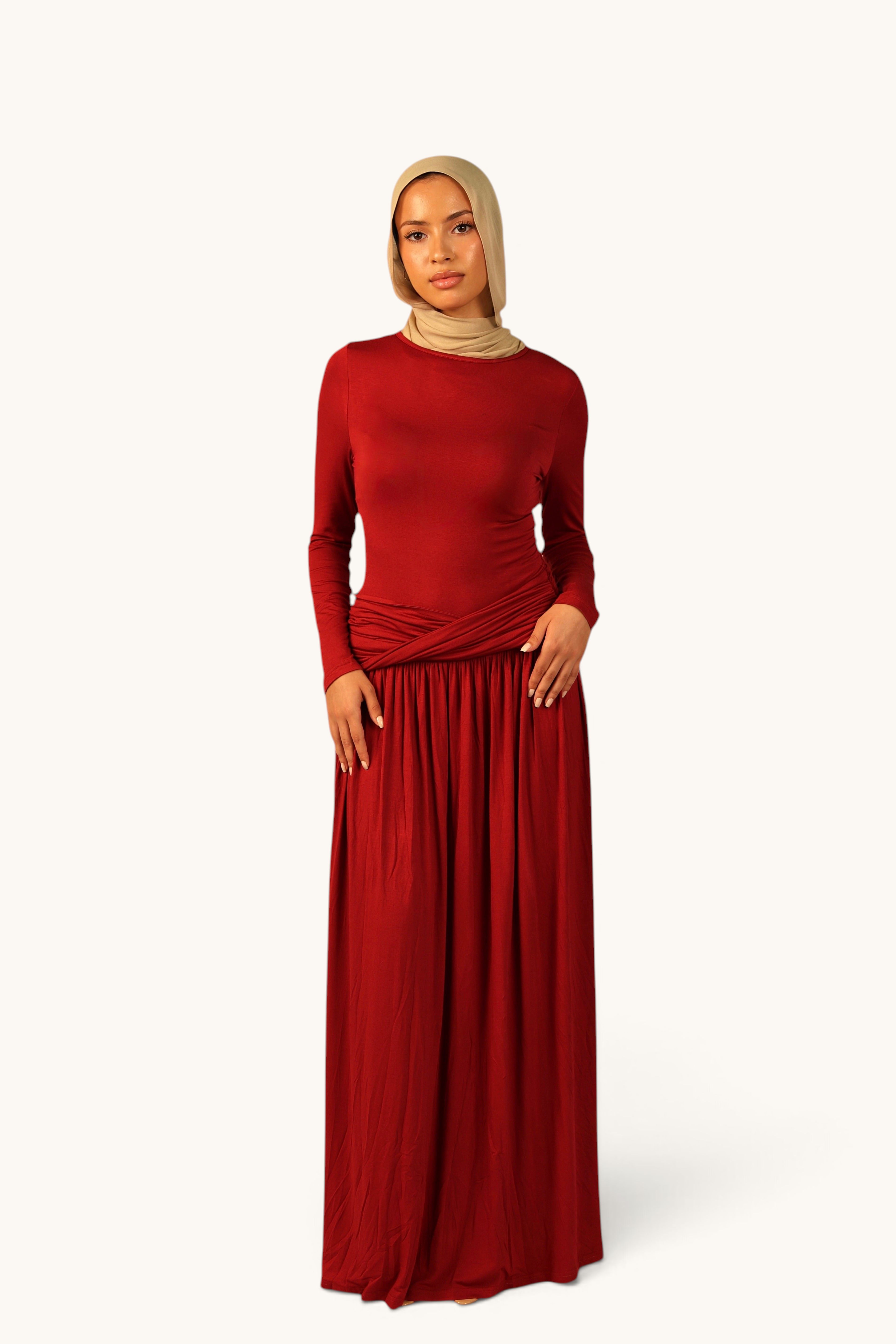 LOSYANA Marbella Jersey-Kleid in Rot mit langem Ärmel, Knotendetail an der Hüfte und beigem Hijab an einem Model