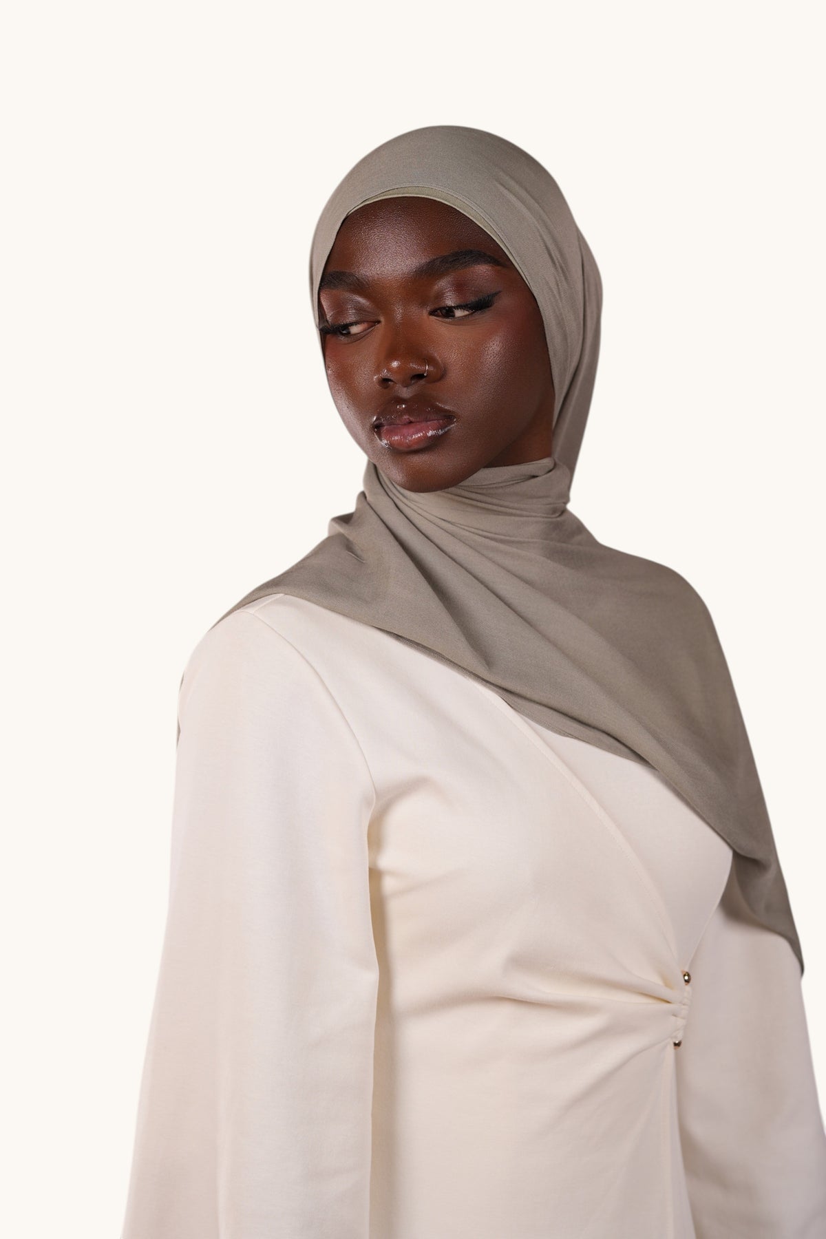 Model wearing a lightweight sage green LOSYANA modal hijab with a matching undercap against a white background