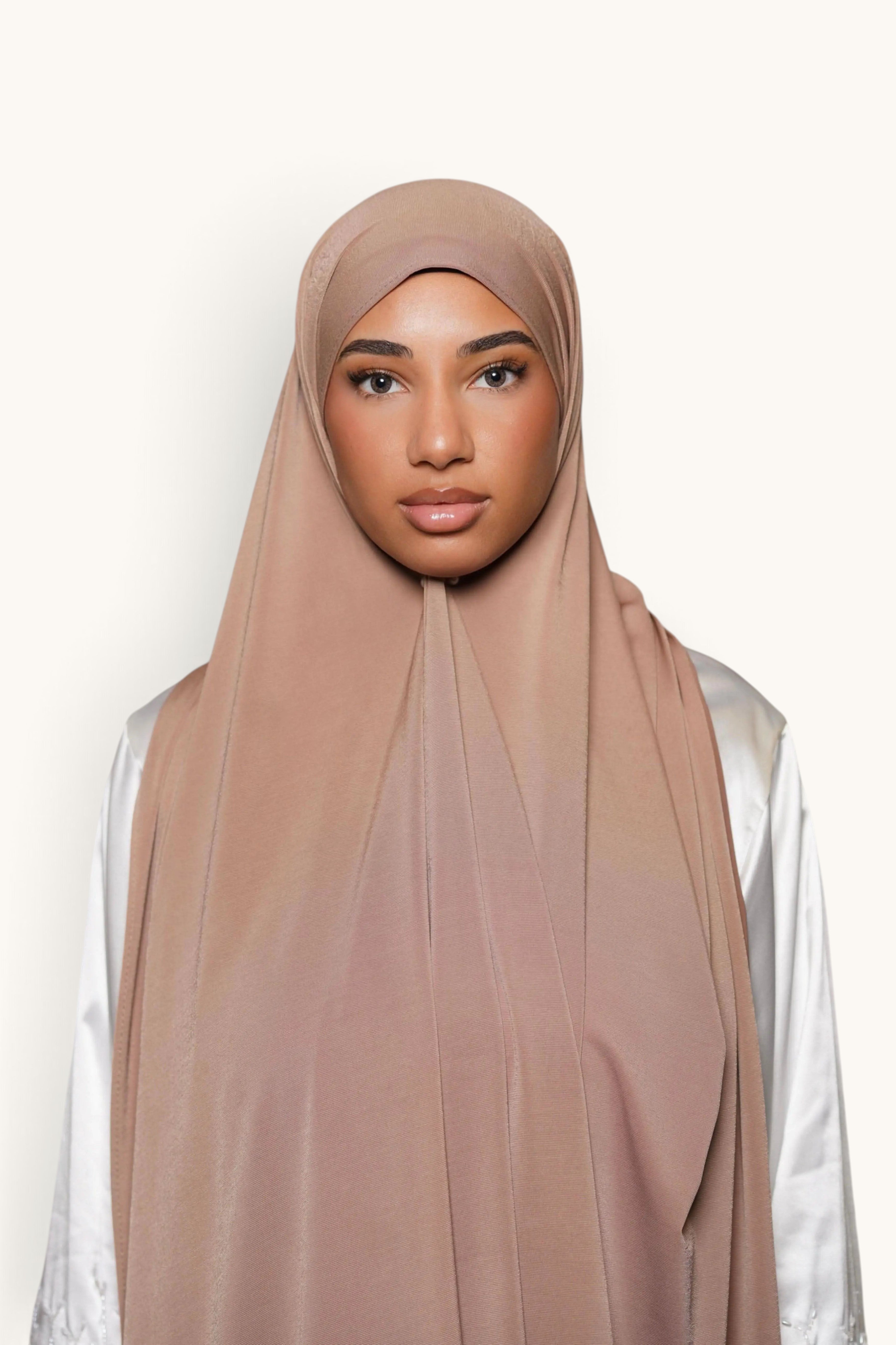 Model wearing a LOSYANA sand-coloured satin jersey hijab with a smooth, opaque, and non-slip drape.