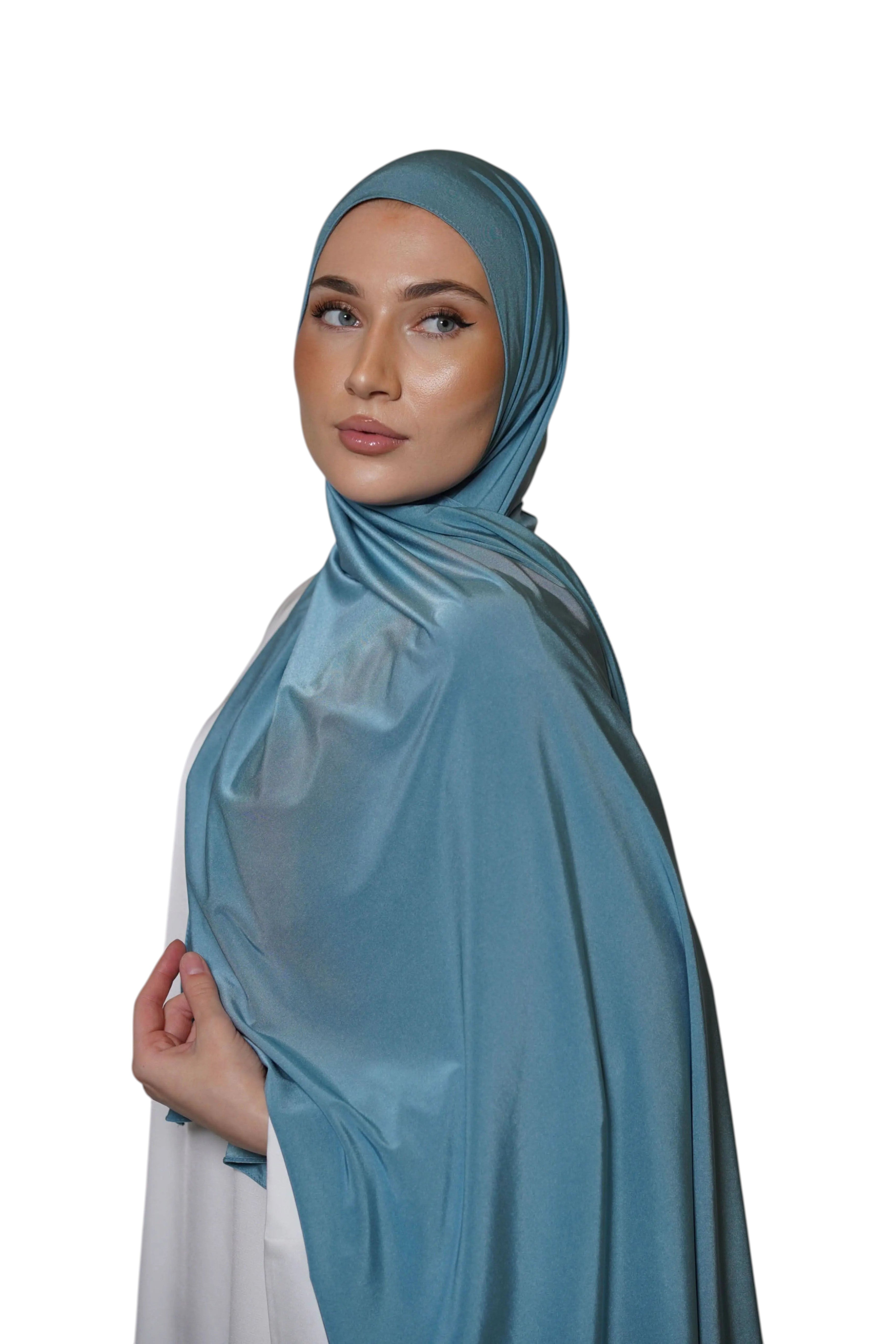 Model wearing a sky blue LOSYANA satin jersey hijab with a smooth, non-slip drape against a white background.
