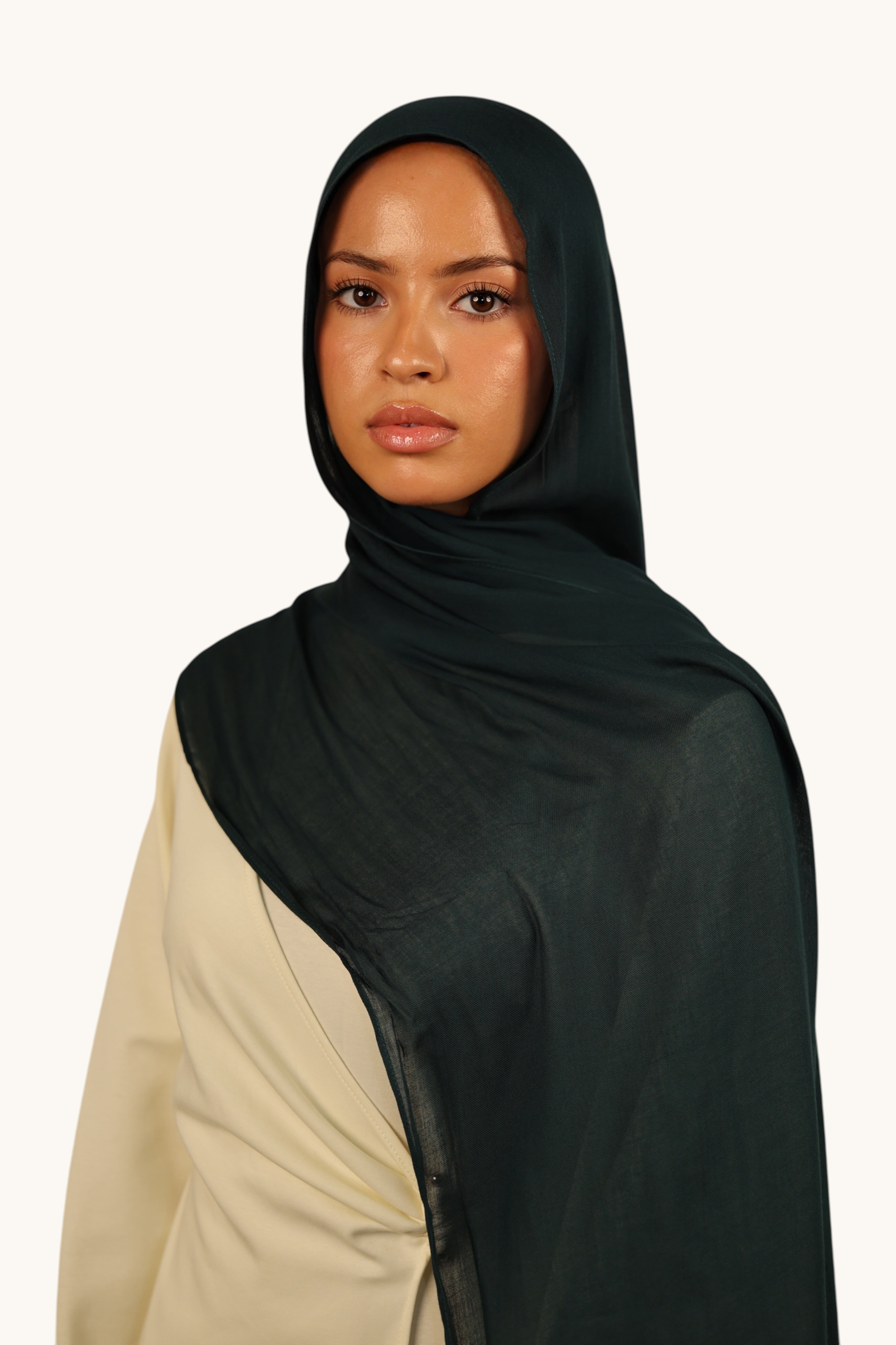 Model wearing a LOSYANA teal green lightweight modal hijab with a matching undercap, elegant flowing fabric.