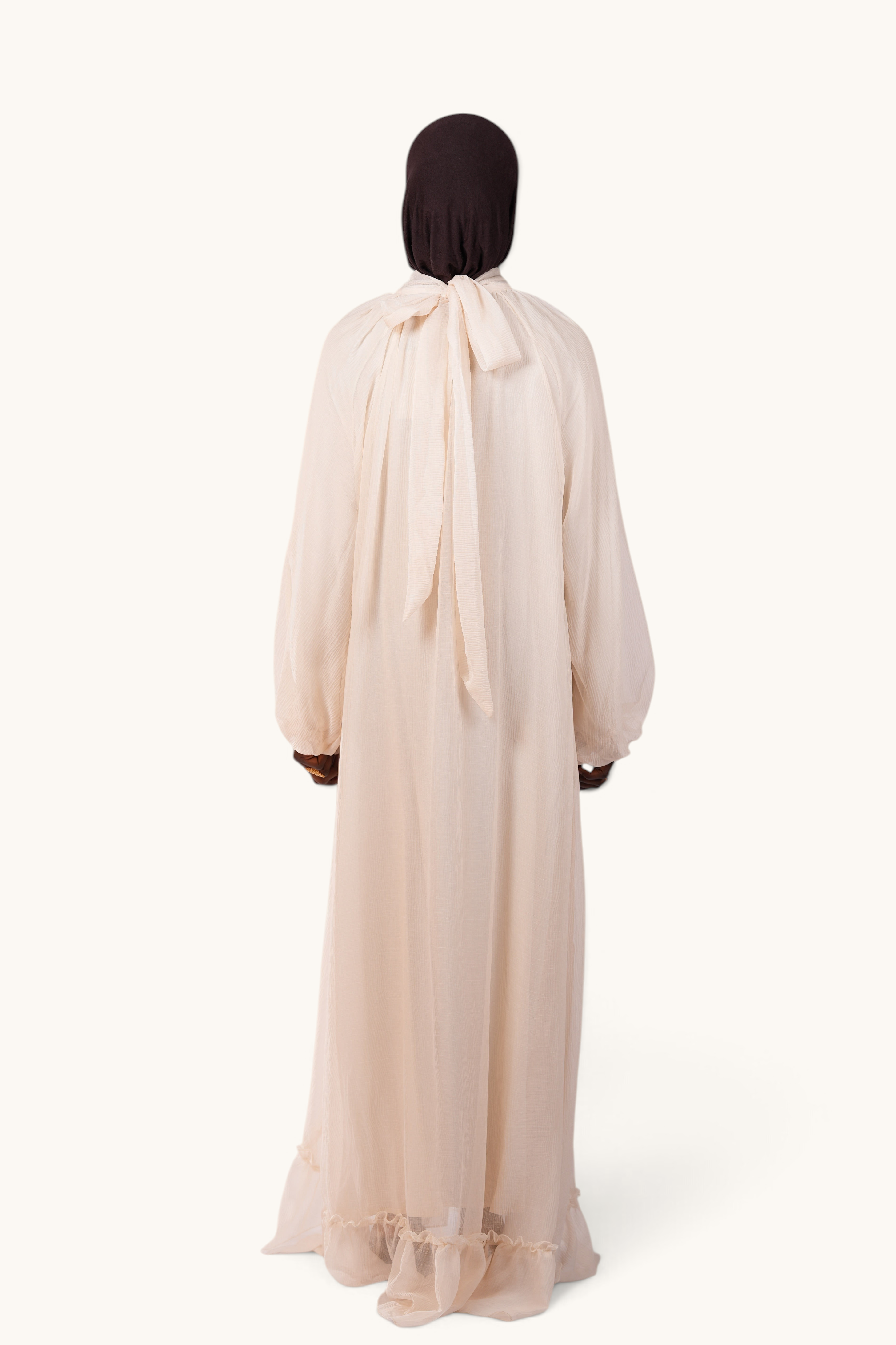 LOSYANA Tenerife ivory crepe maxi dress with balloon sleeves, high collar, and back bow tie detail on a model