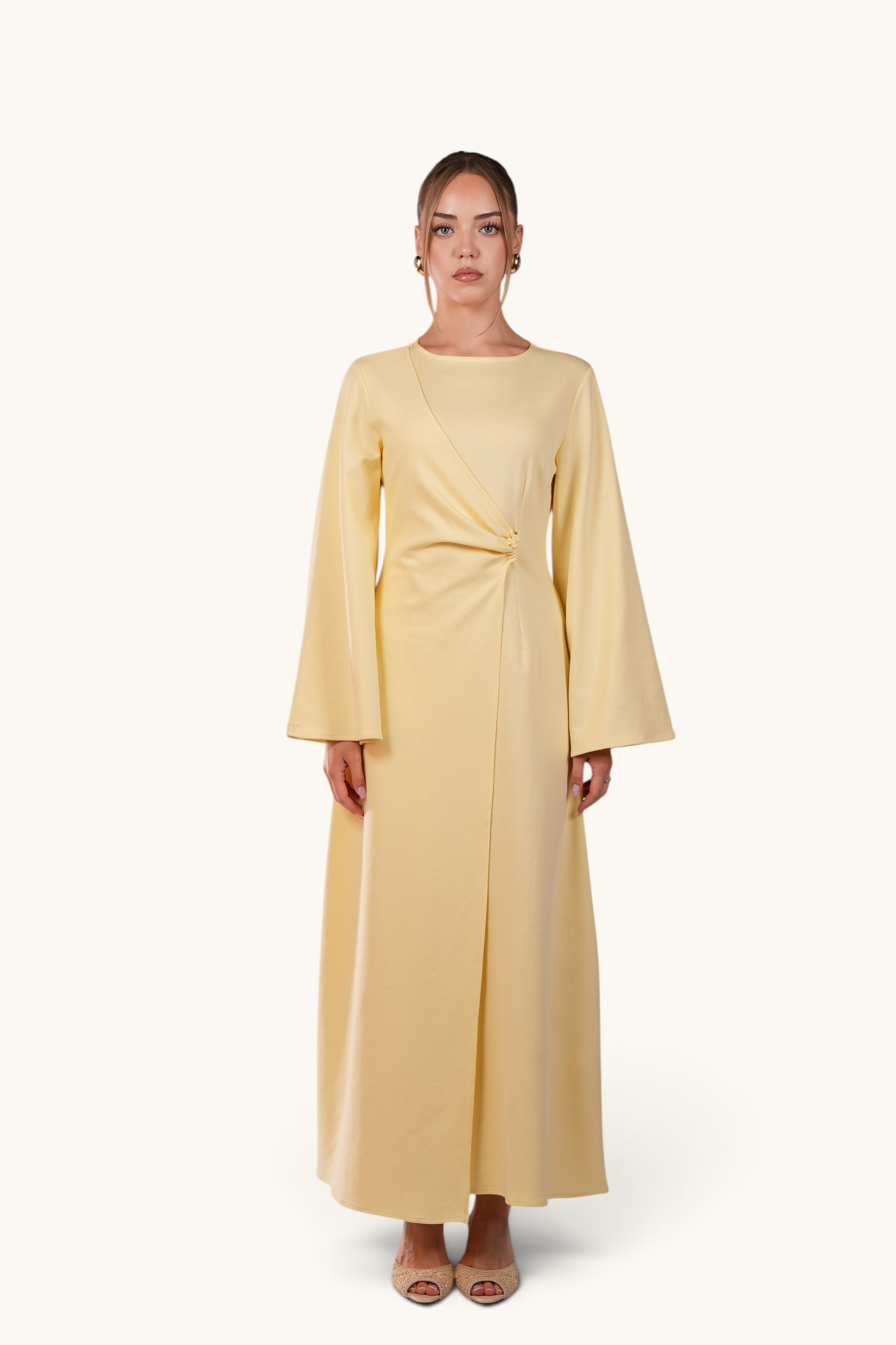 LOSYANA Valencia butter yellow maxi dress with trumpet sleeves and gold waist detail worn by a model