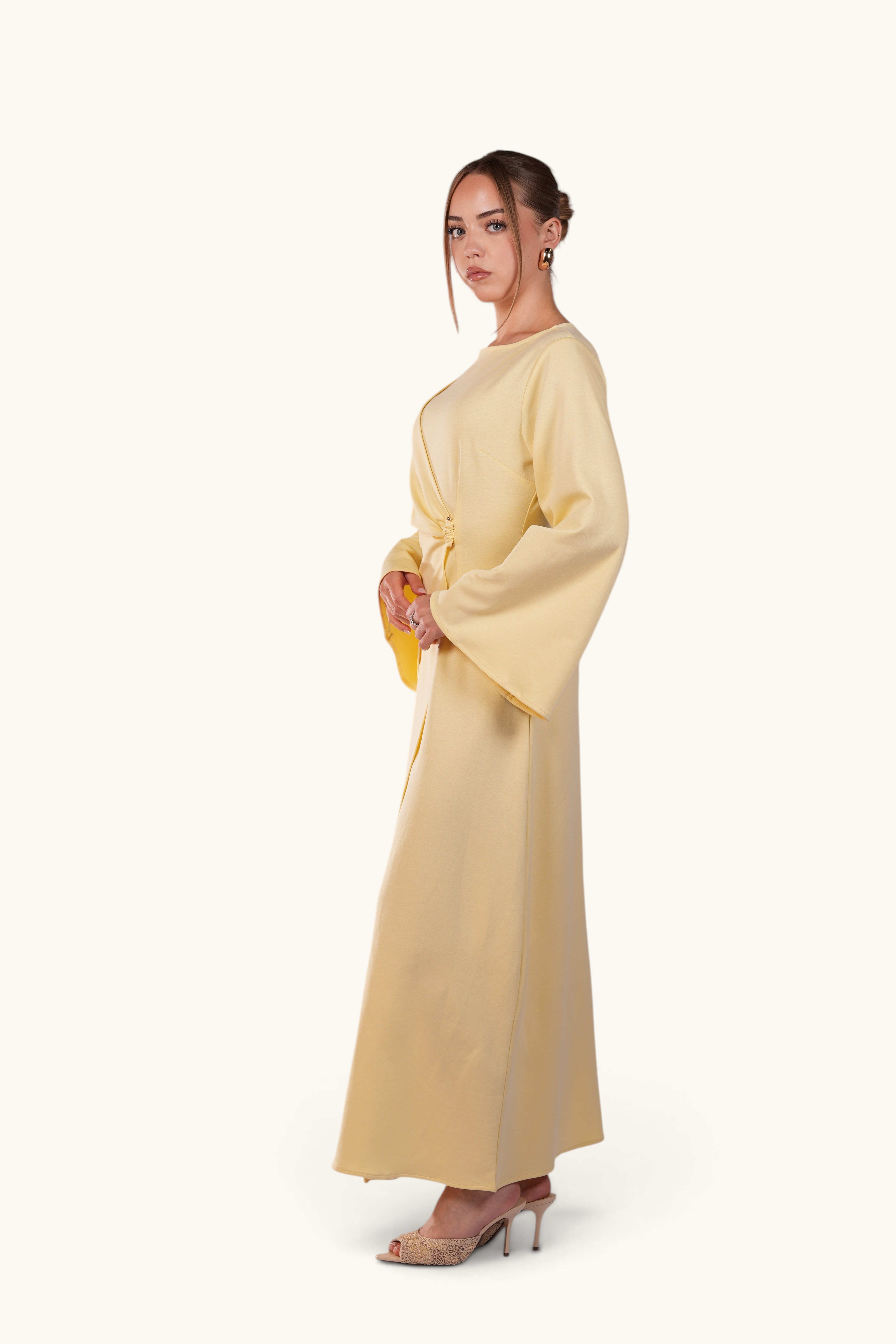 LOSYANA Valencia butter yellow maxi dress with trumpet sleeves and gold waist detail worn by a model