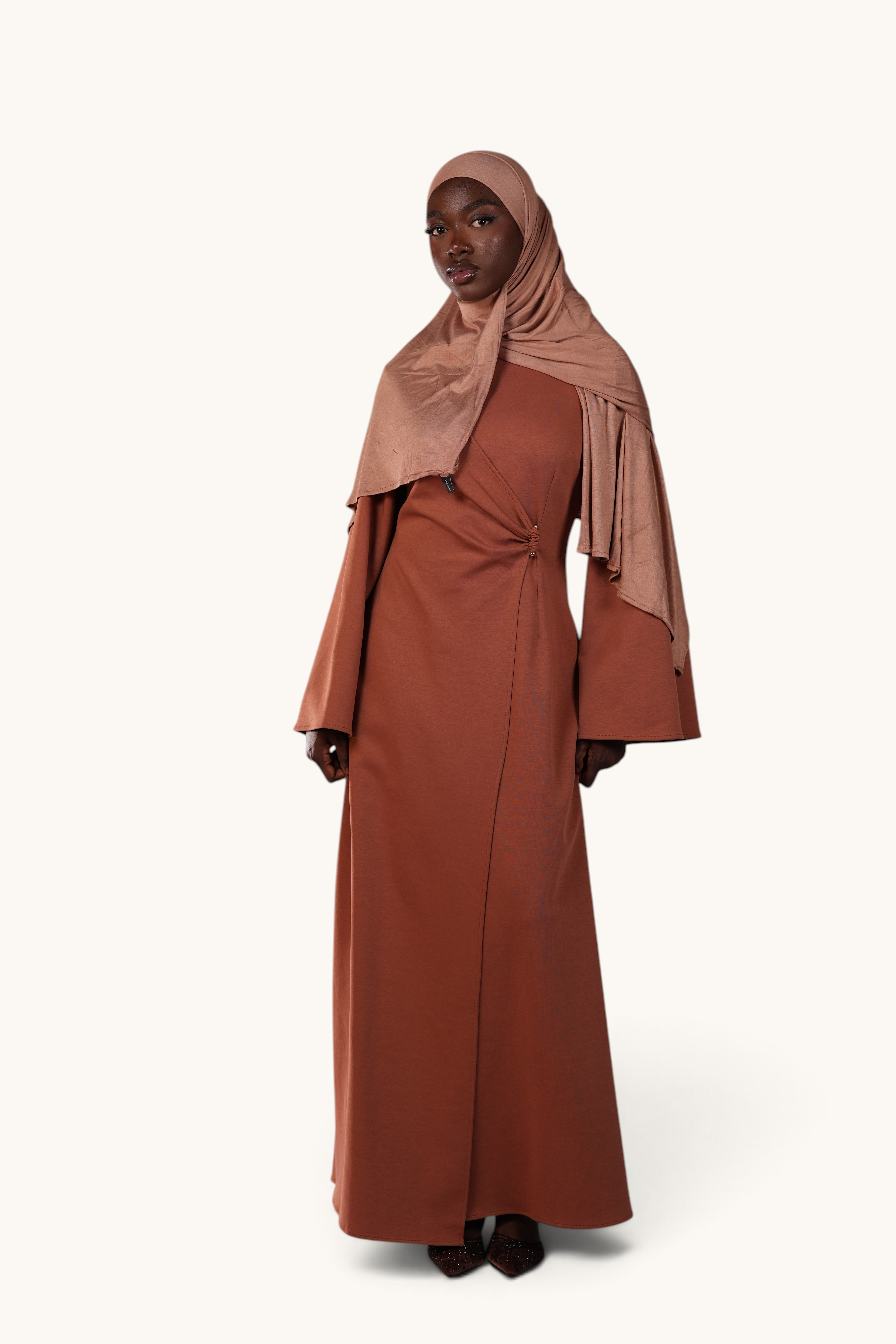 LOSYANA Valencia terracotta maxi dress with trumpet sleeves, gold waist detail, and matching hijab on a model