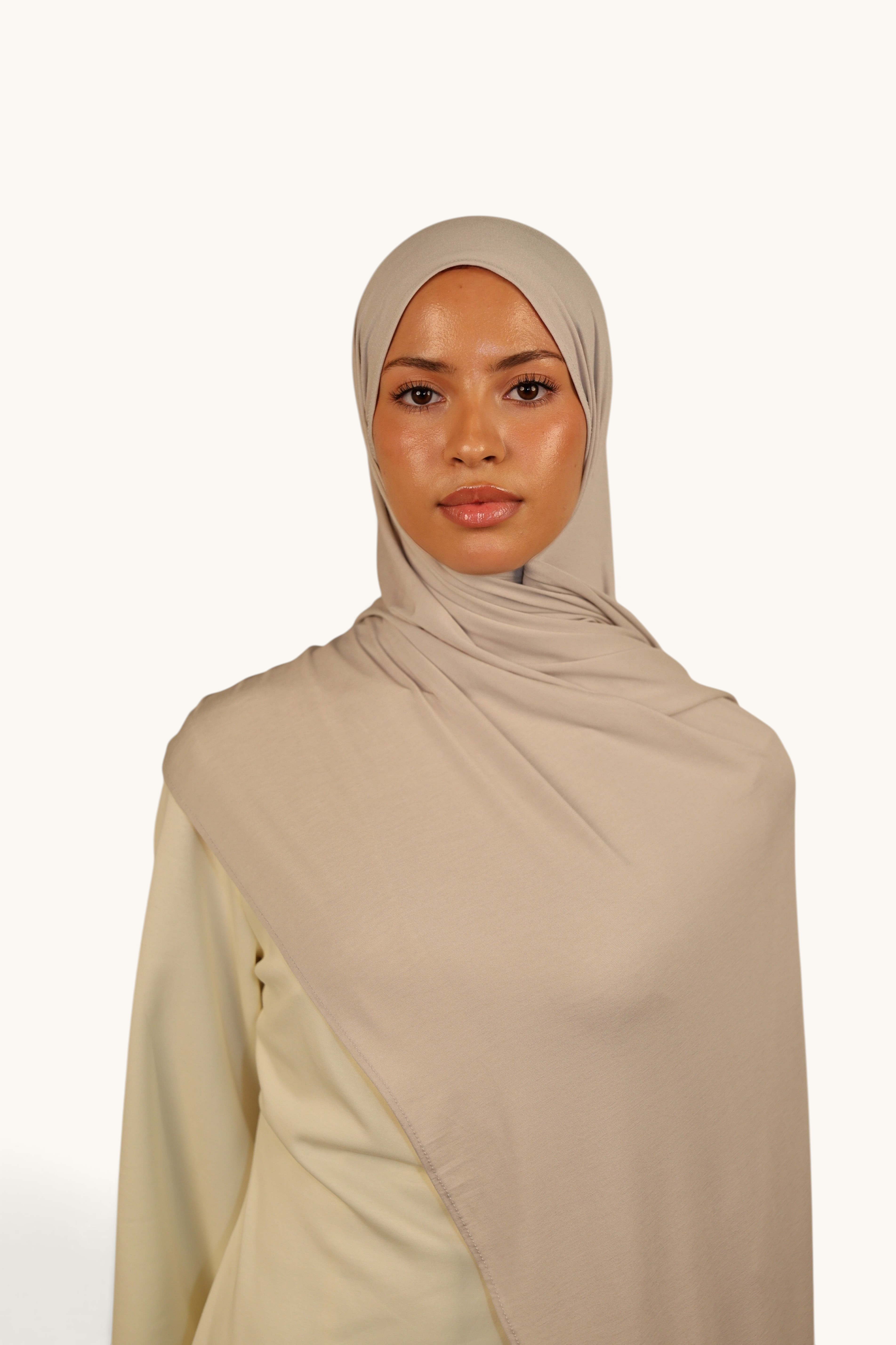 Model wearing a LOSYANA Vela Jersey hijab in ash beige, crafted from soft, breathable, lightweight fabric.