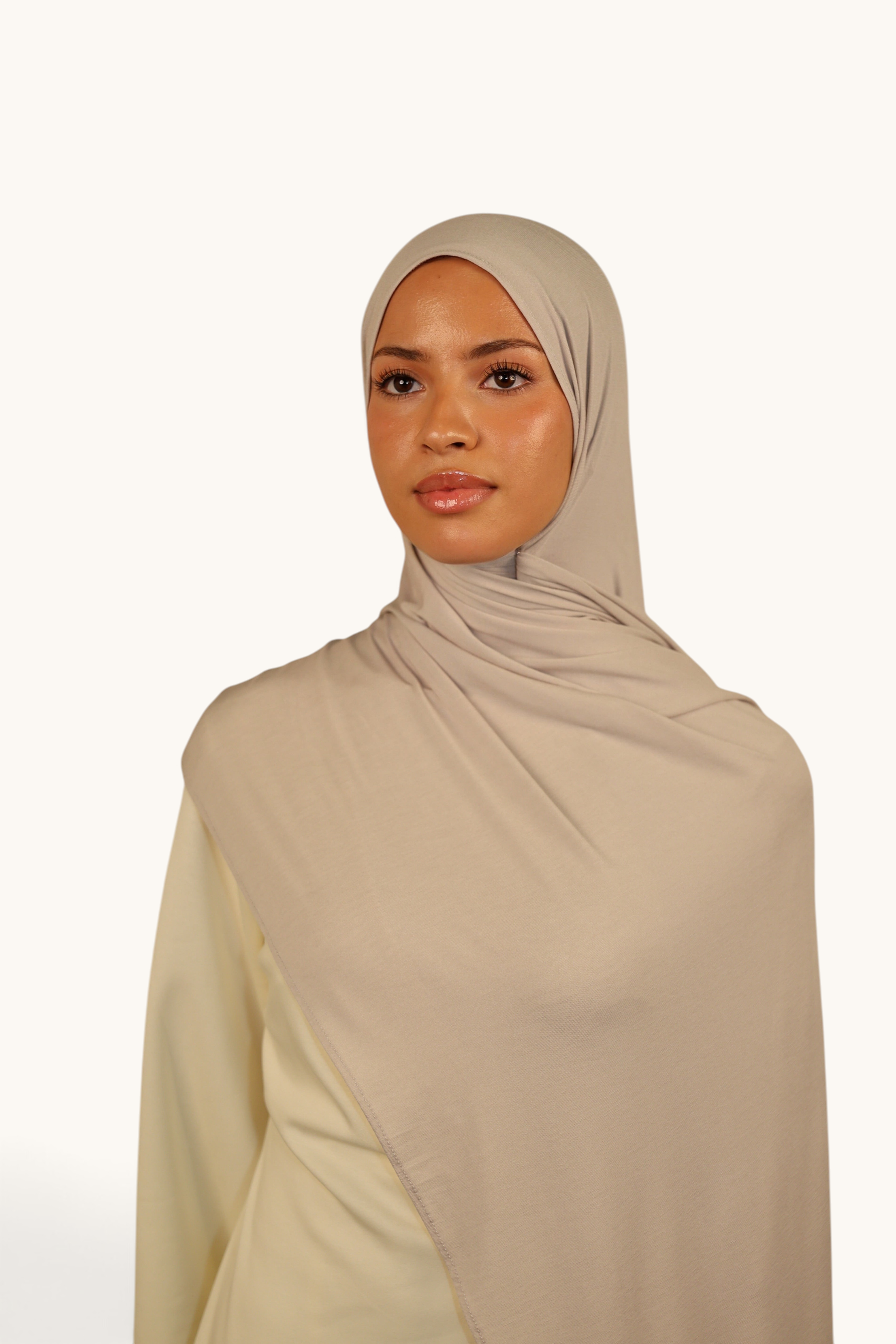 Model wearing a LOSYANA Vela Jersey hijab in ash beige, crafted from soft, breathable, lightweight fabric.