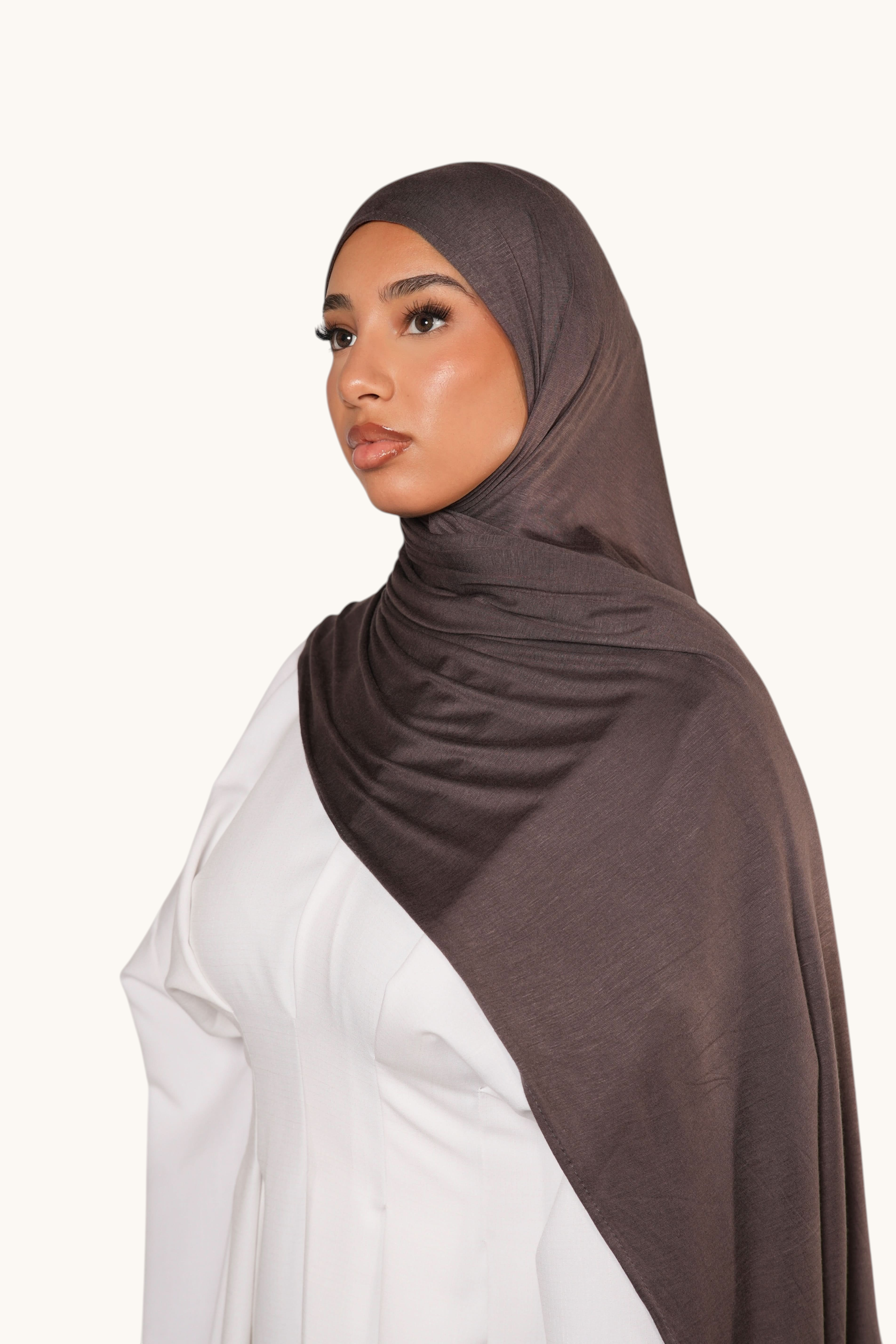 Model wearing a brown sugar LOSYANA Vela Jersey hijab made of soft, breathable fabric against a neutral background