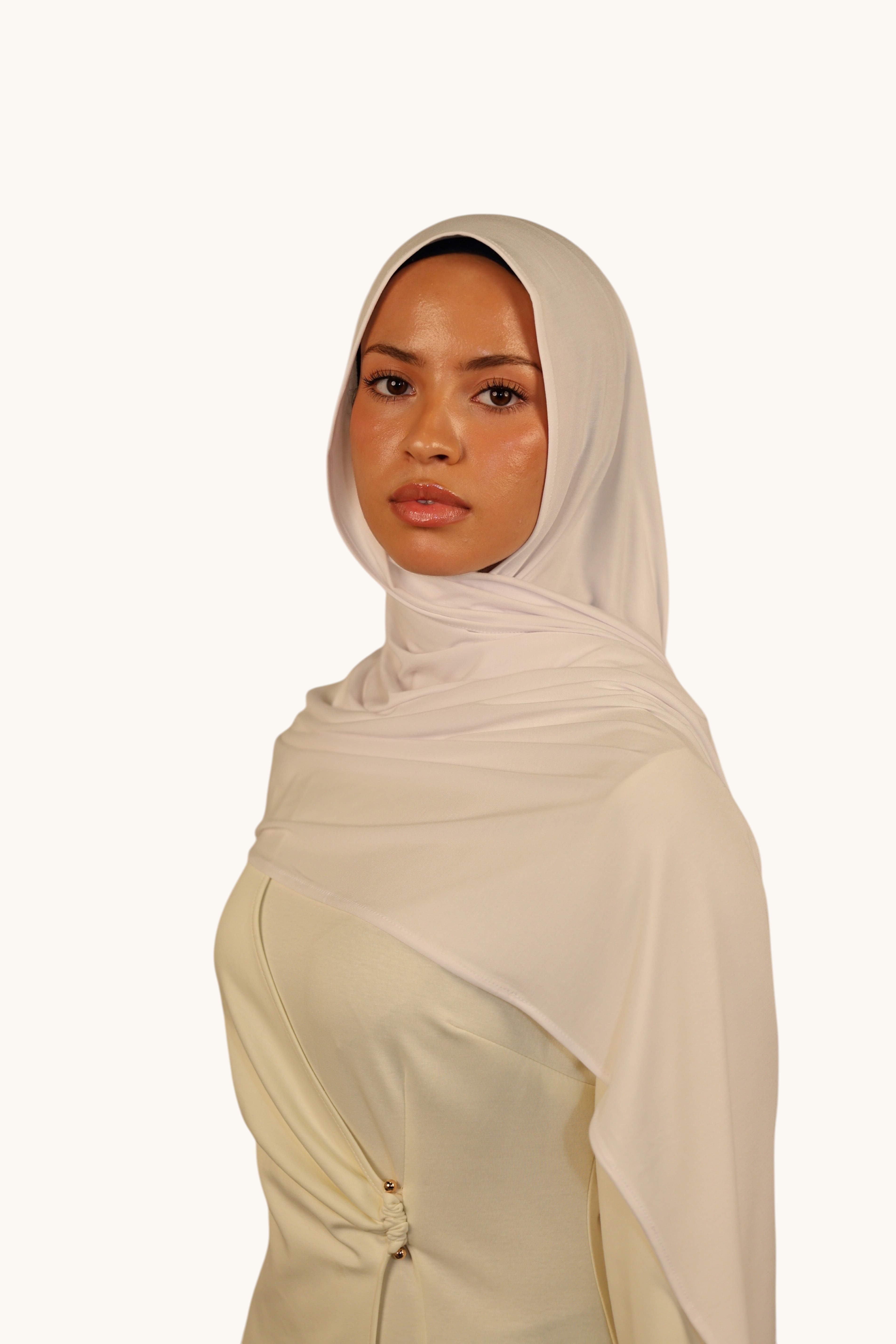 Model wearing a LOSYANA Vela Jersey in cold white, a soft and lightweight fabric styled as an elegant headscarf.