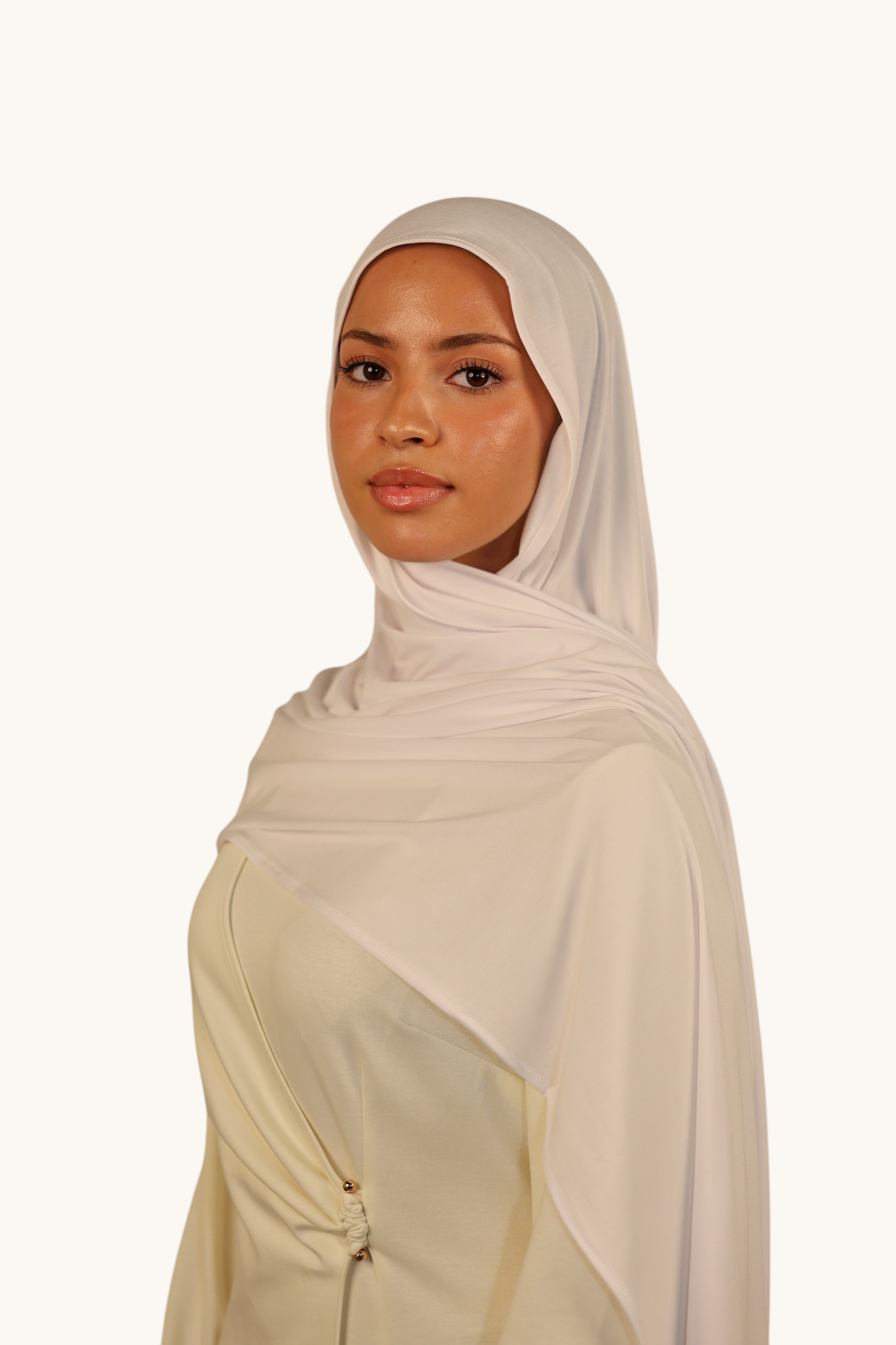 Model wearing a LOSYANA Vela Jersey in cold white, a soft and lightweight breathable fabric hijab.