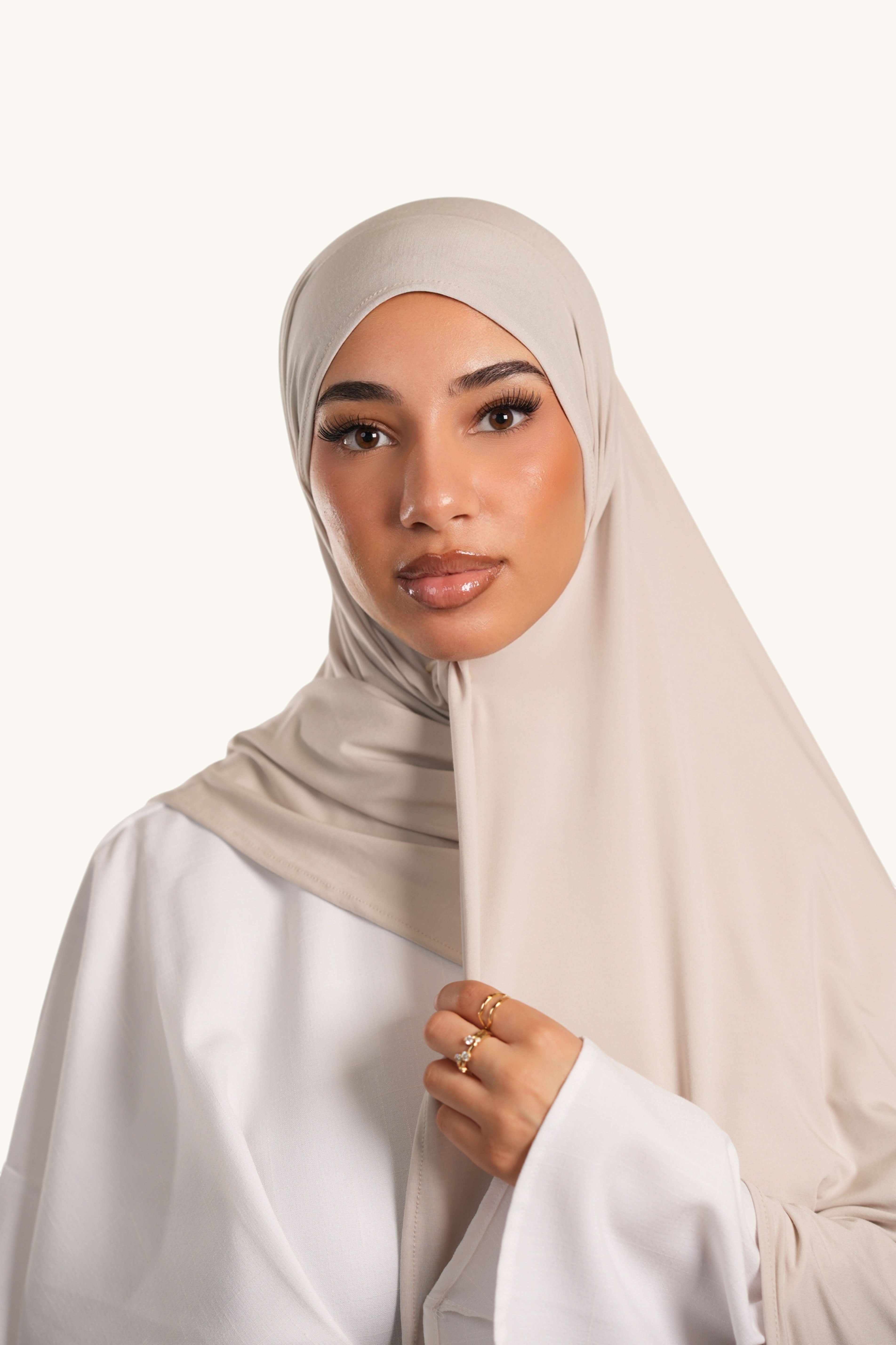 Model wearing a light beige LOSYANA Vela Jersey hijab, crafted from soft, breathable fabric for versatile styling.