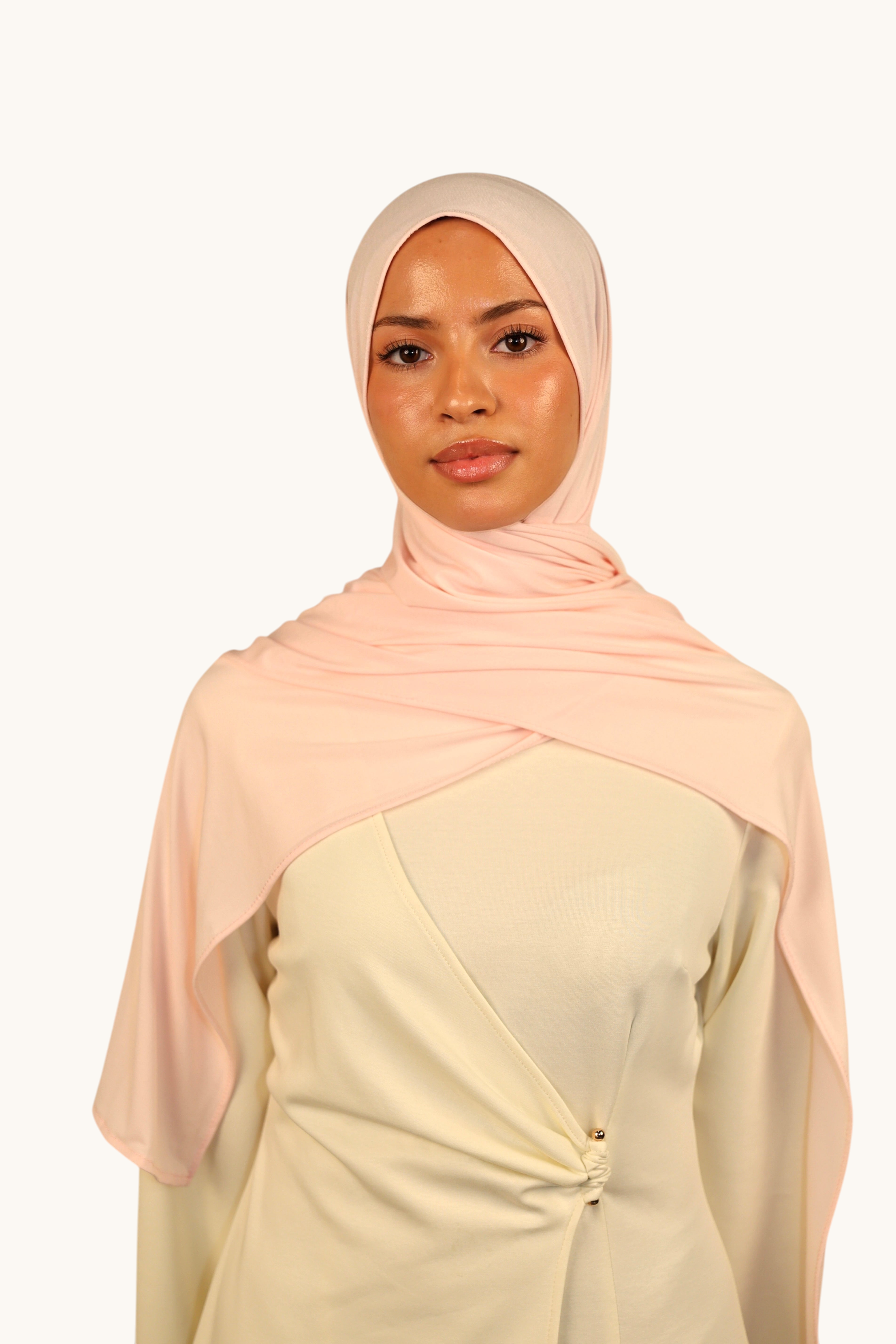 Model wearing a light rose LOSYANA Vela Jersey hijab made of soft, breathable fabric, styled elegantly.