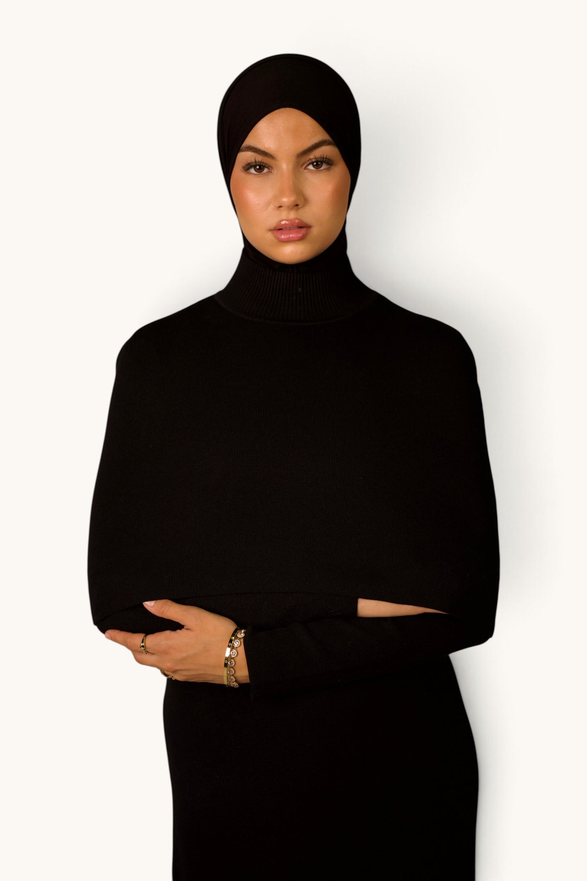 LOSYANA schwarzes Strickkleid mit Cape-Detail und Rollkragen an einem Model