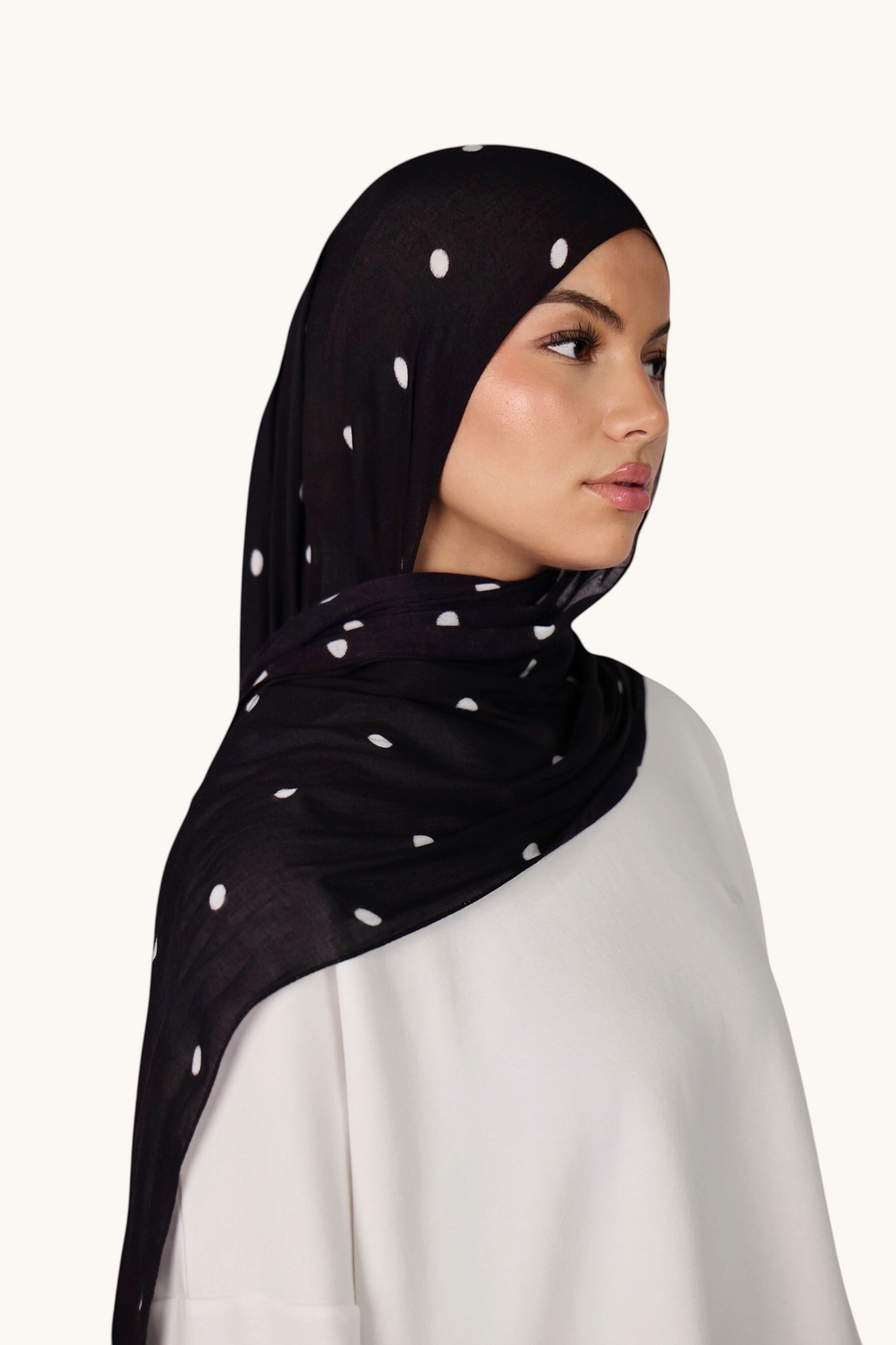 LOSYANA Hijab aus schwarzem Modal mit weißen Velour-Punkten, getragen von einem Model für einen eleganten Look.